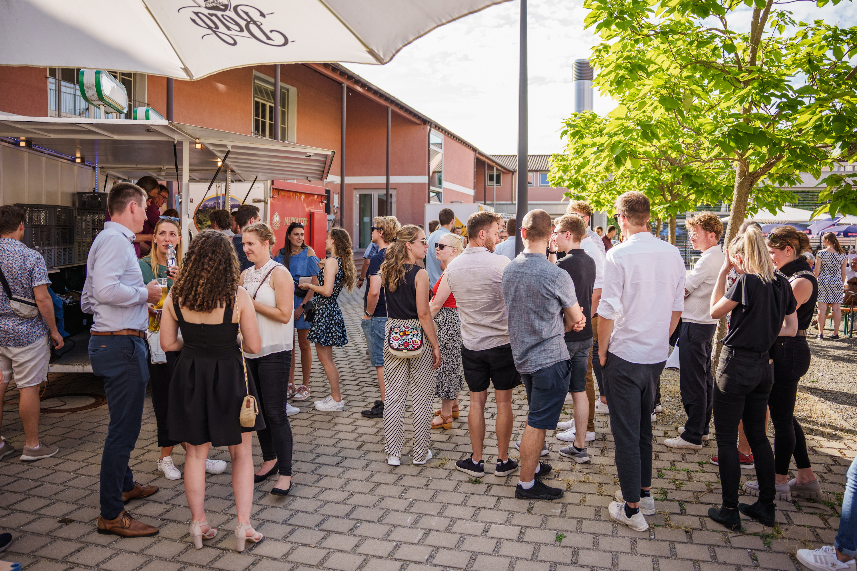 Menschengruppe draußen vor Getränkewagen