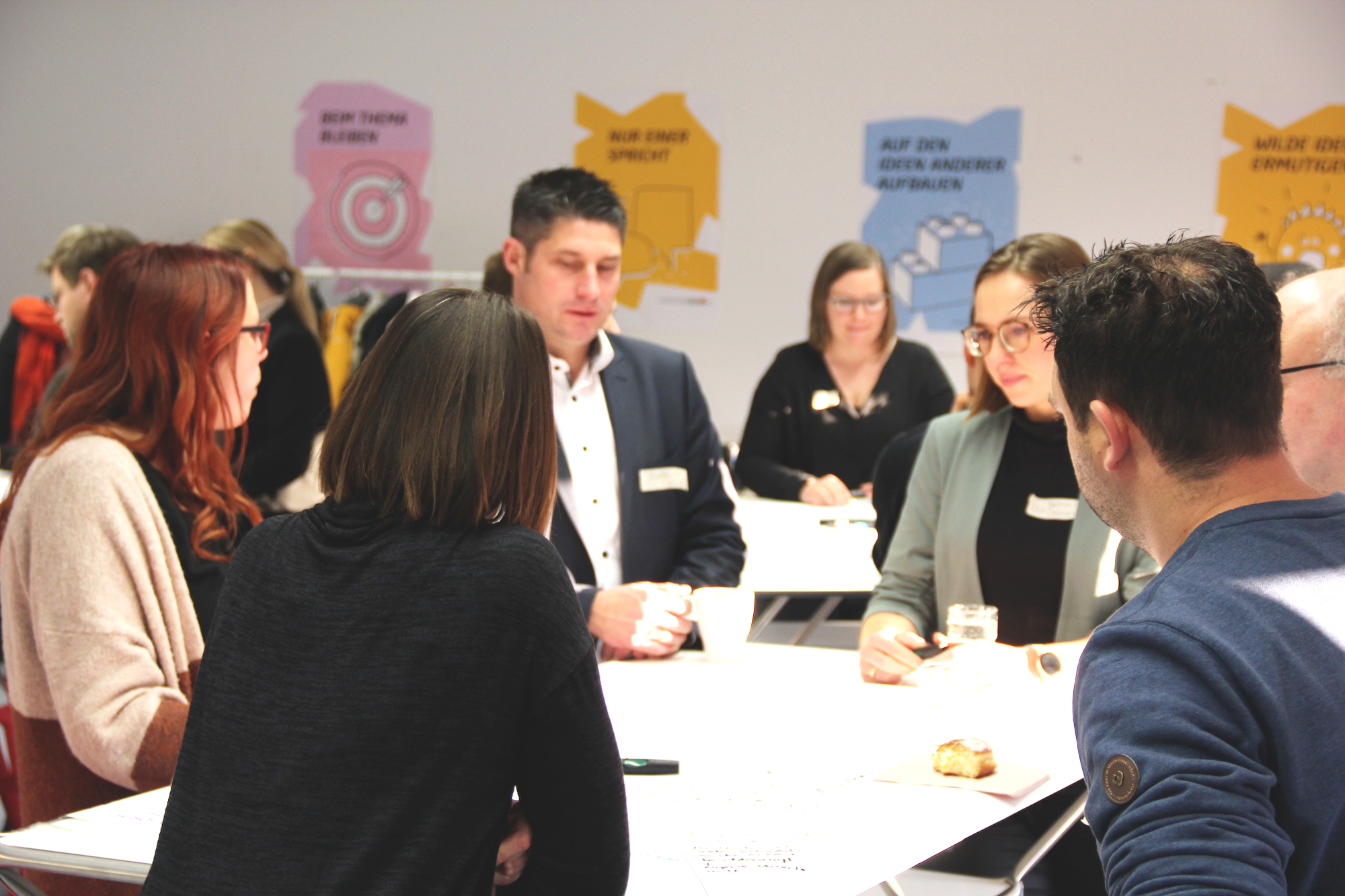 Erwachsene stehen um Tisch herum