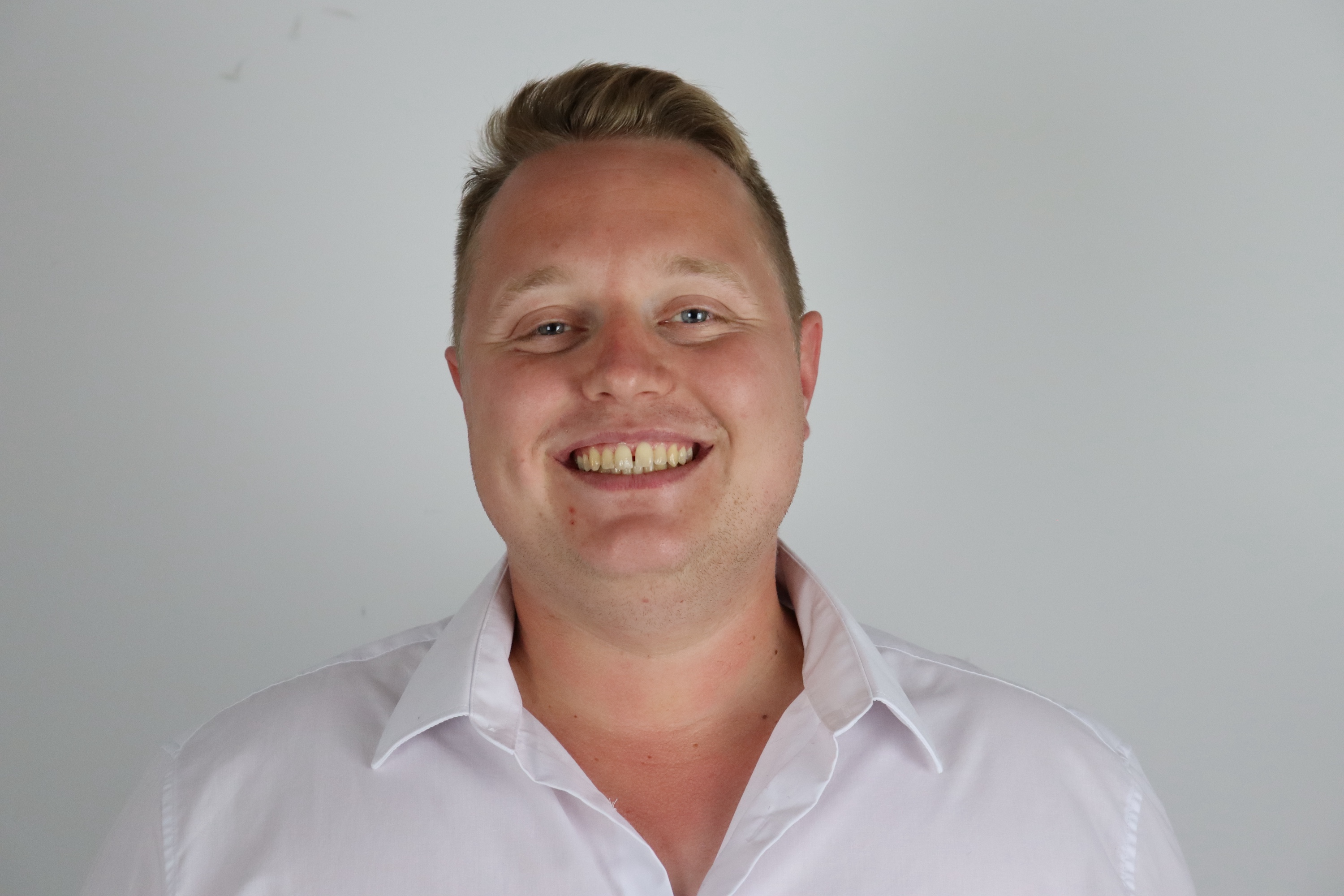 Junger Mann lacht in die Kamera