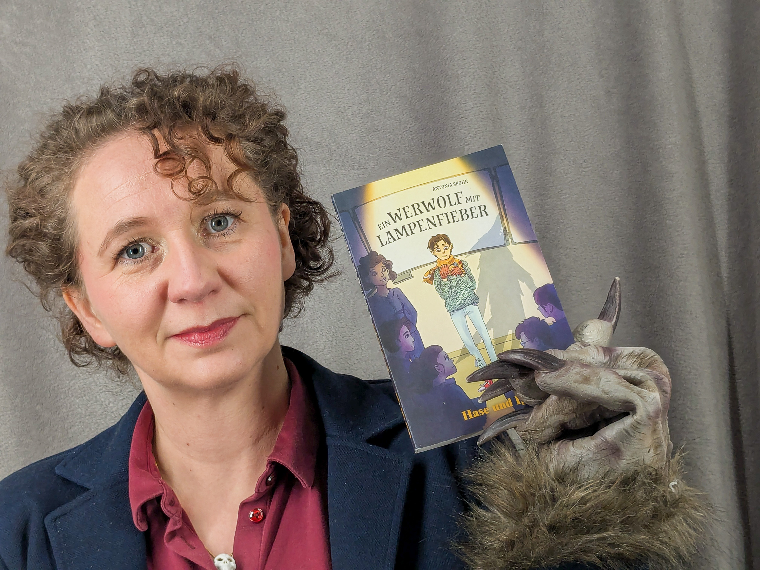 Frau hält Buch in die Kamera 