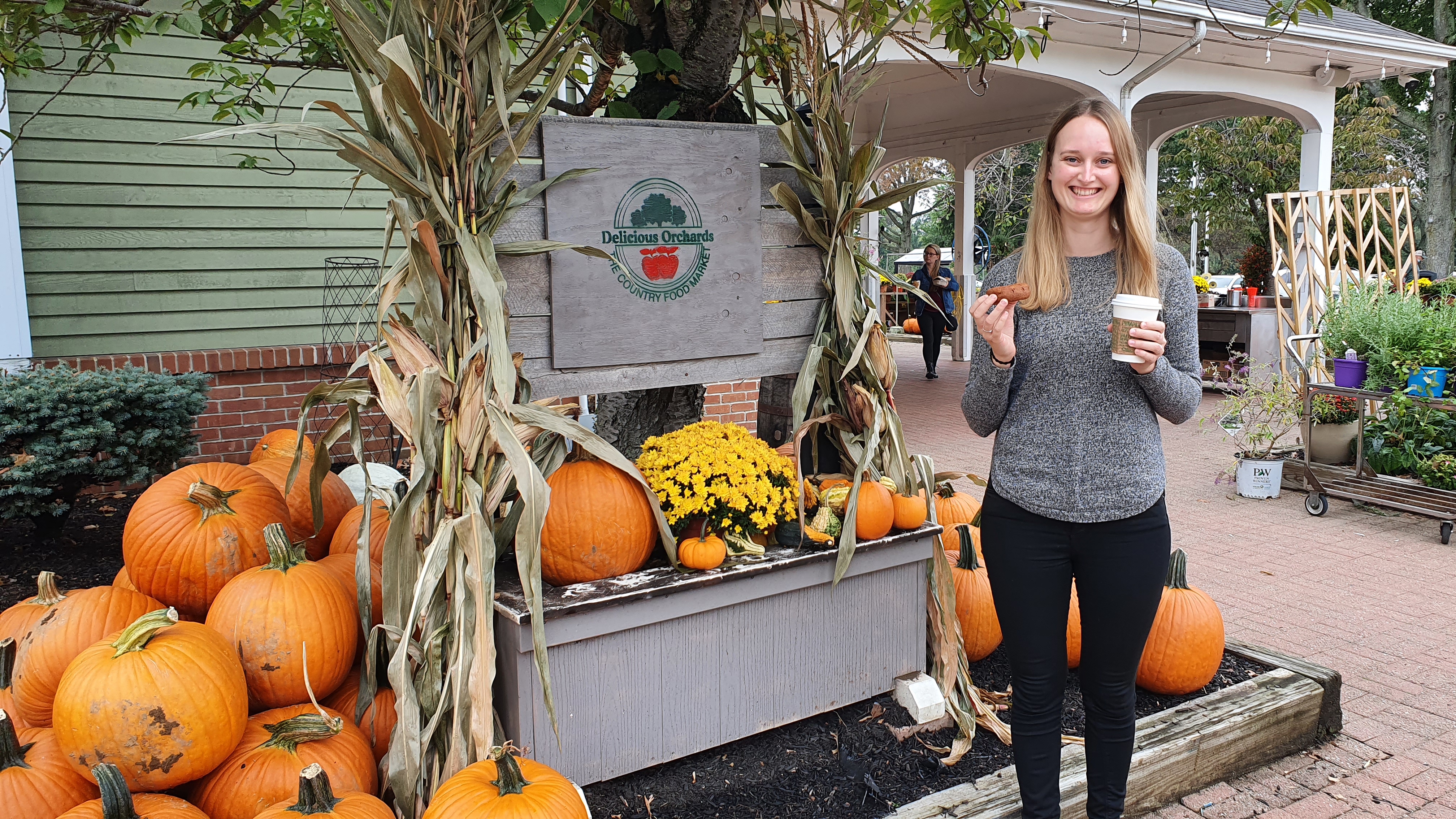 Junge Frau vor einem Kürbisstand in Amerika