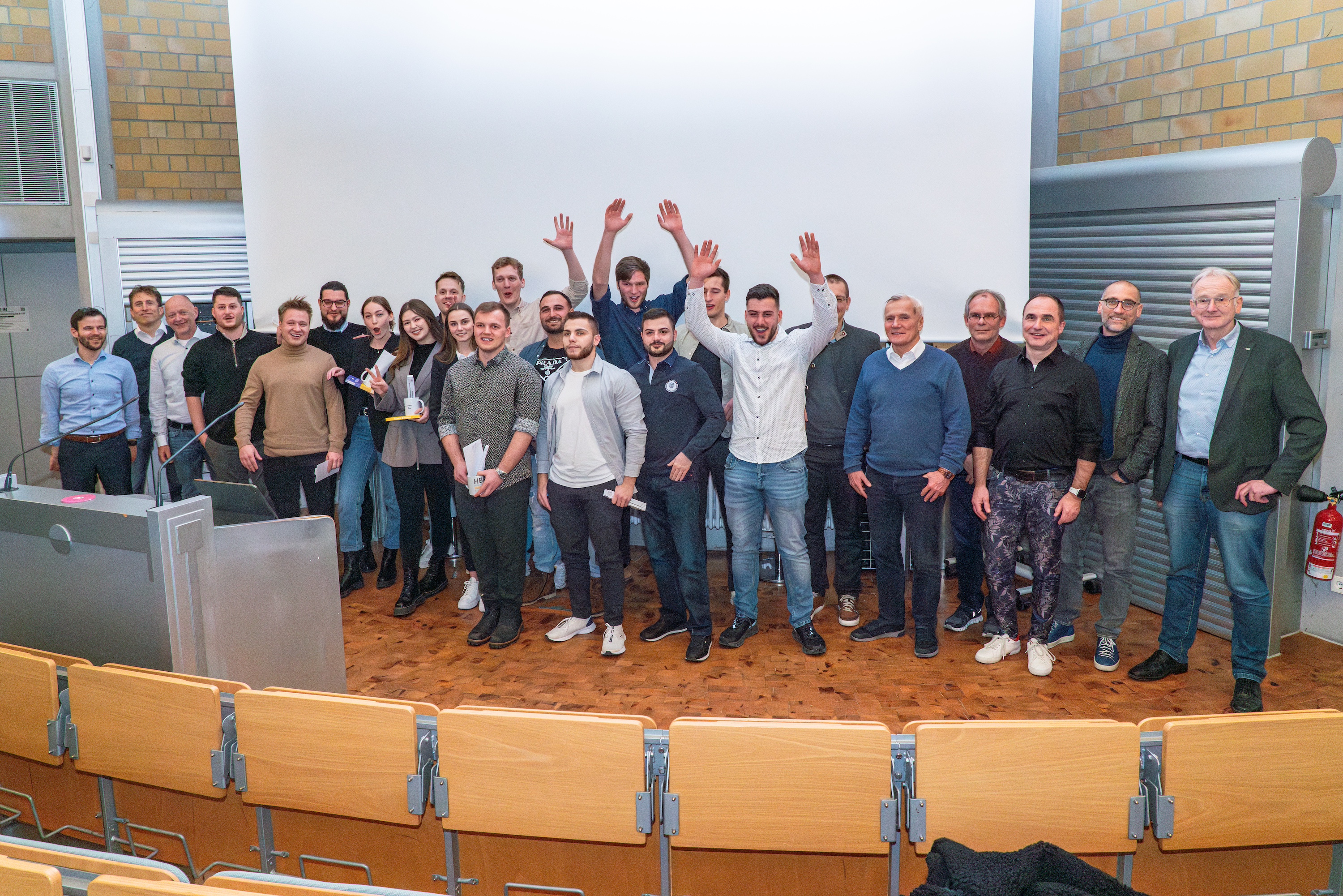 Viele Studierende stehen vor Leinwand und jubeln