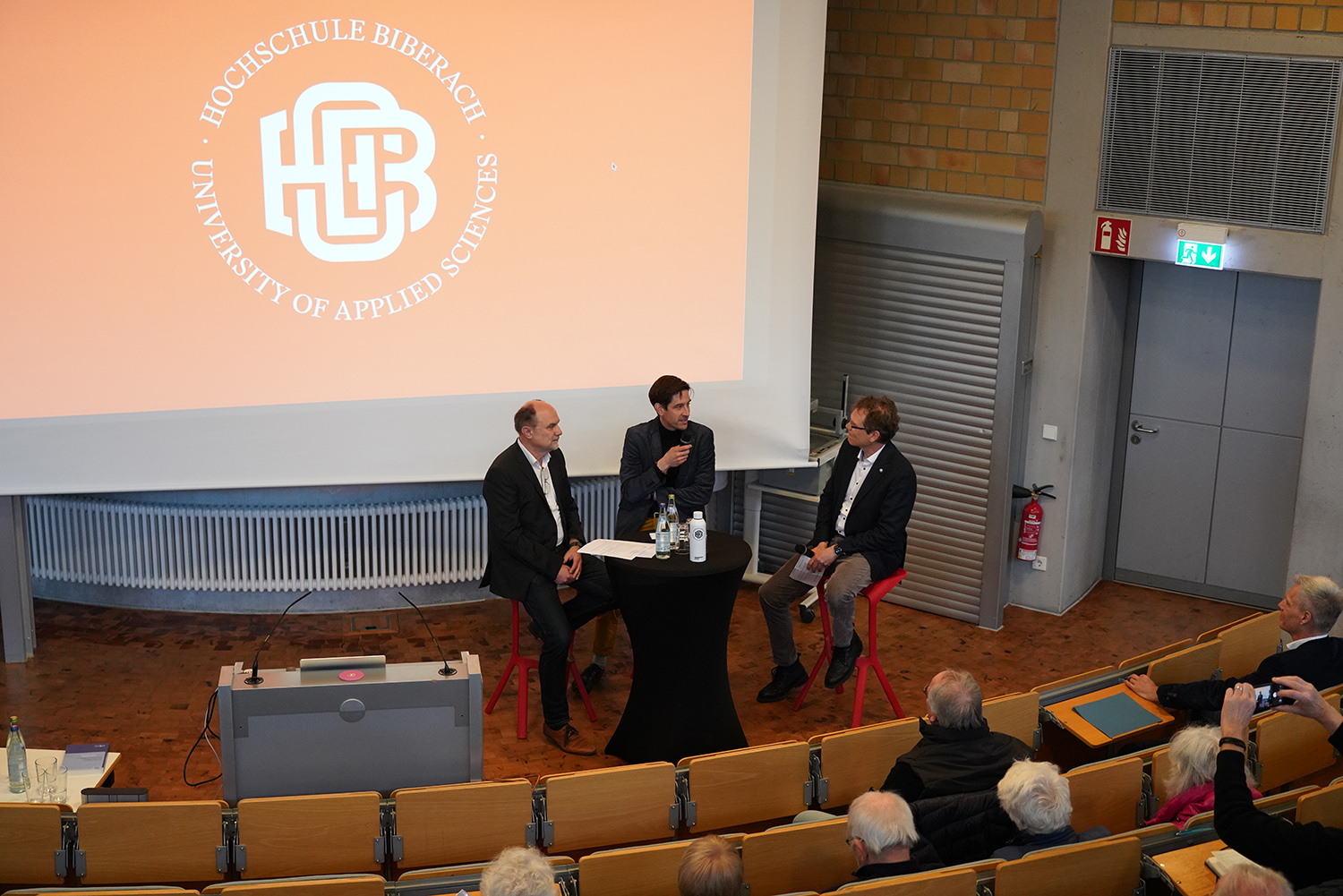 Drei Männer diskutieren an einem Tisch