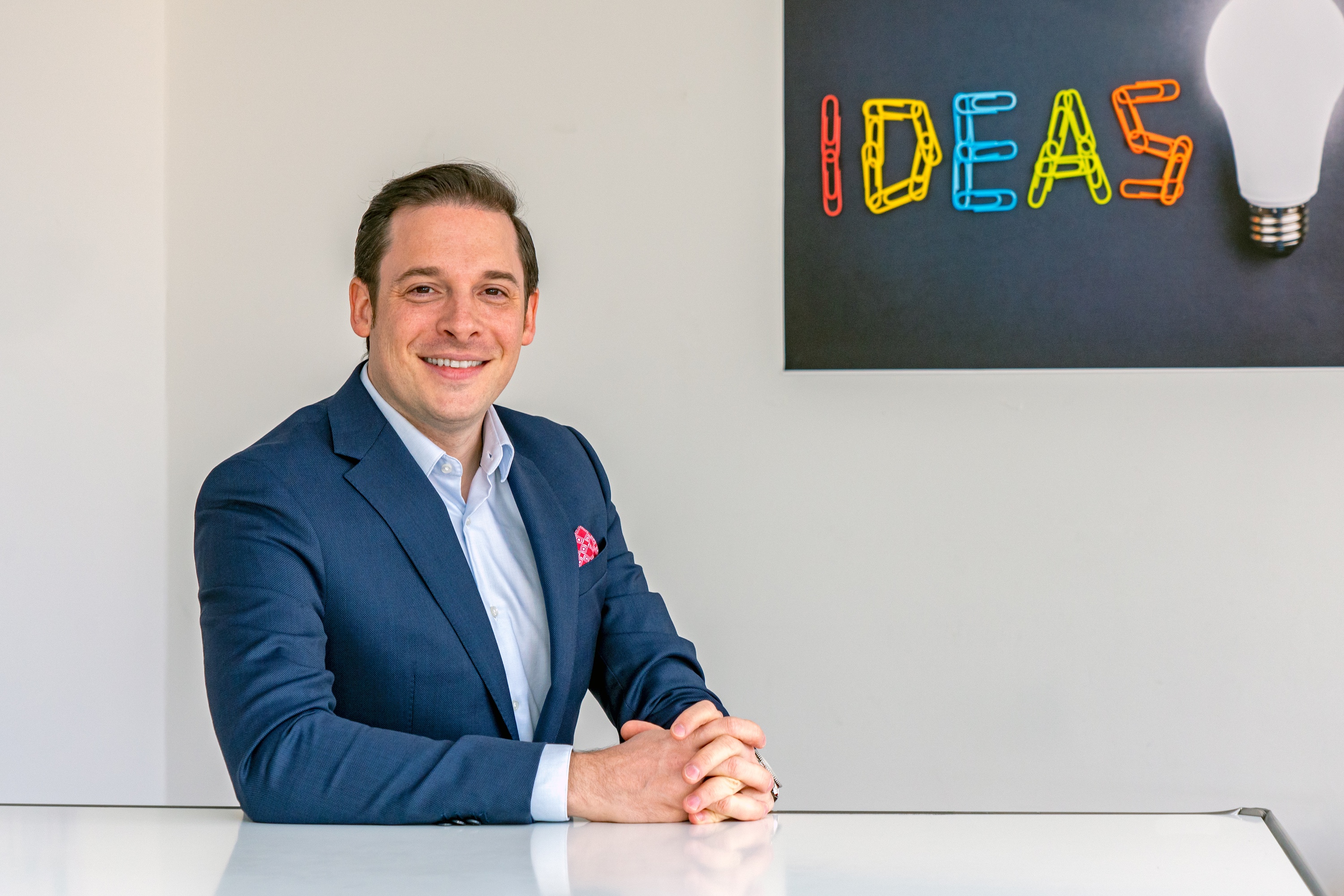 Mann im Anzug sitzt an einem weißen Tisch