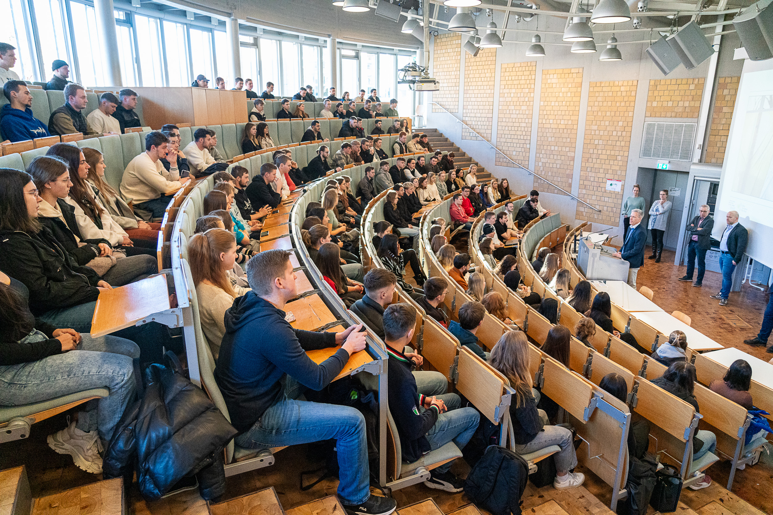 Studierende sitzen im Audimax bei Begrüßung