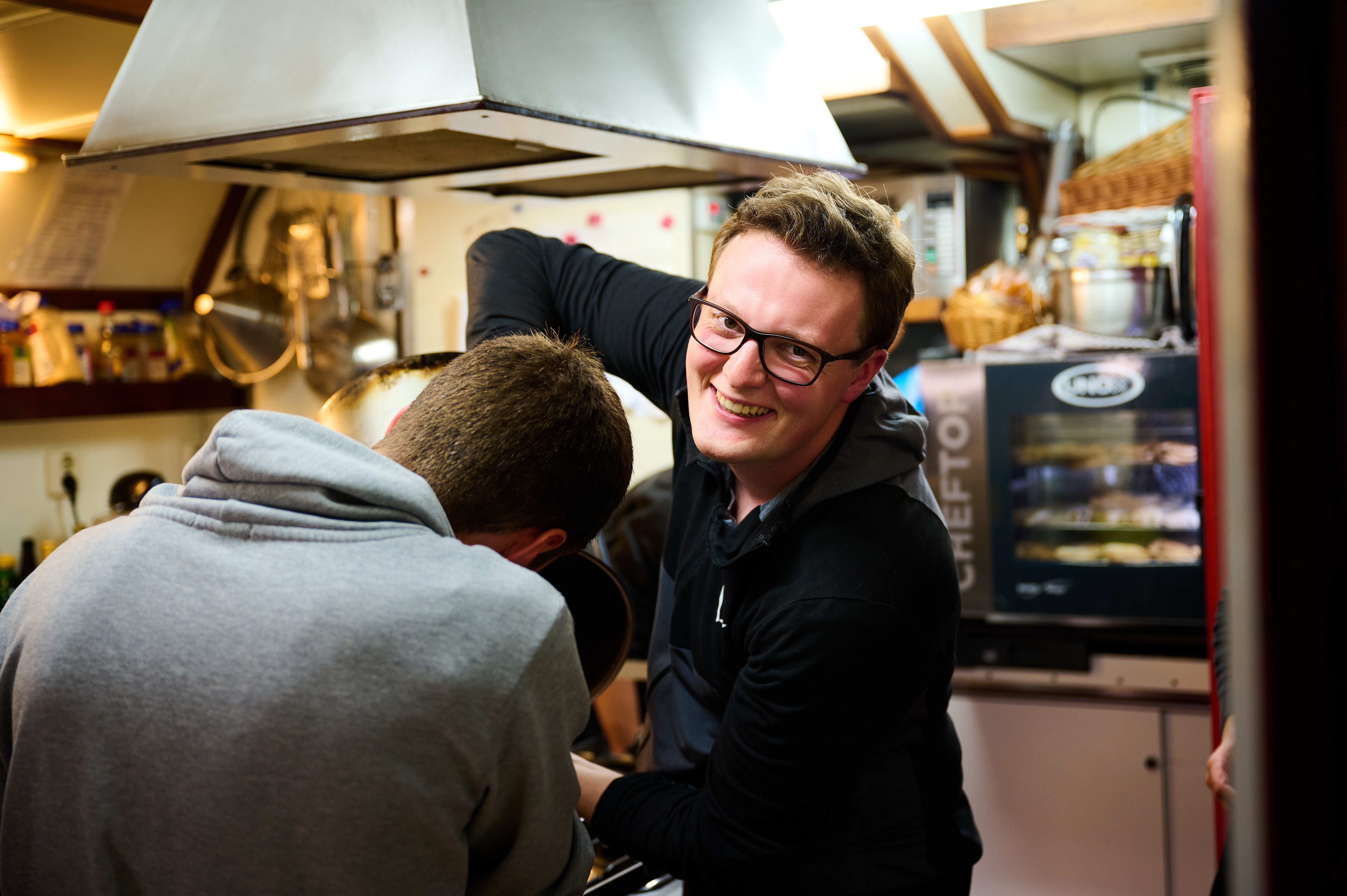 Lachende Person beim Kochen