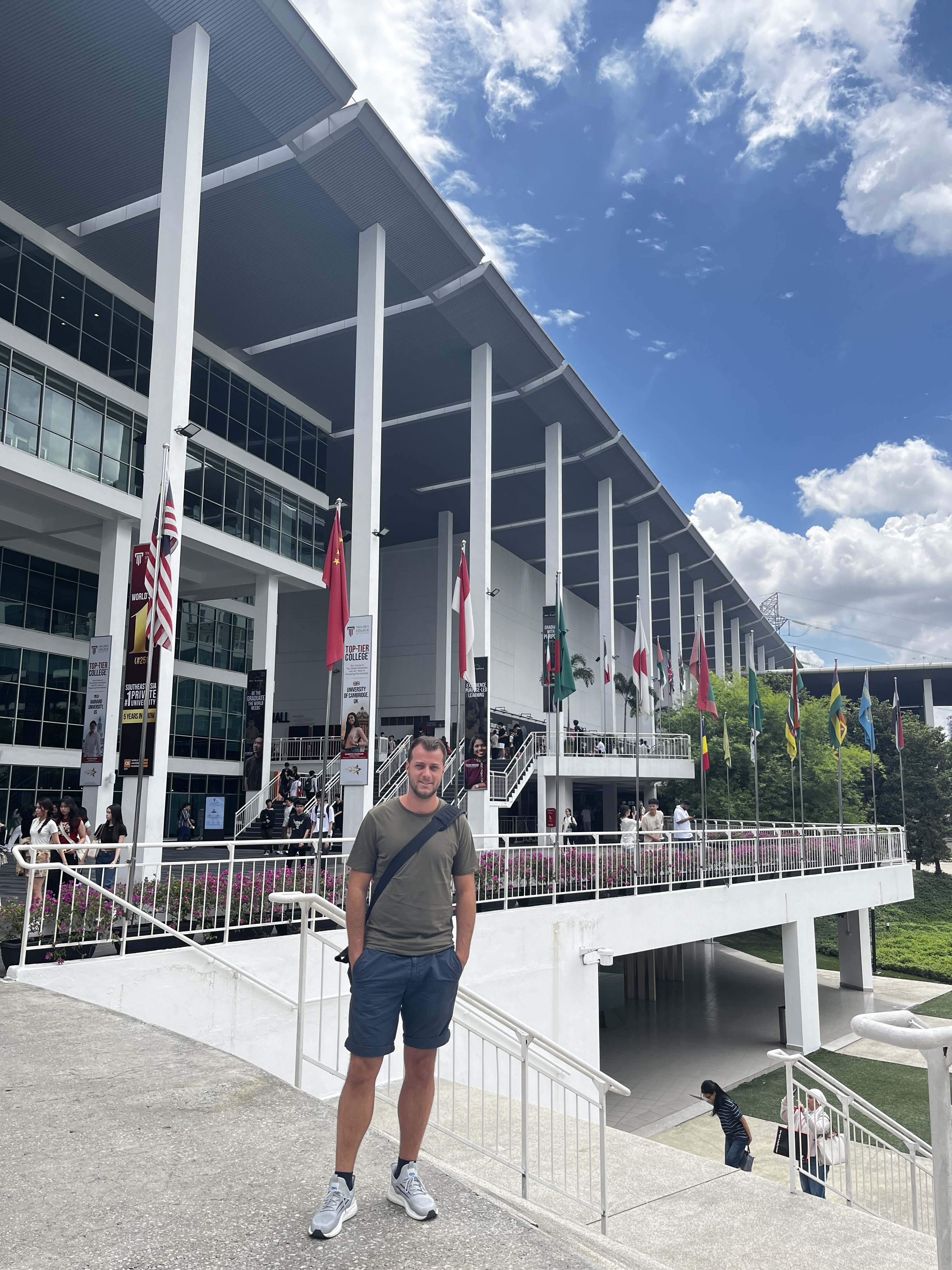 Mann steht vor einem Stadion