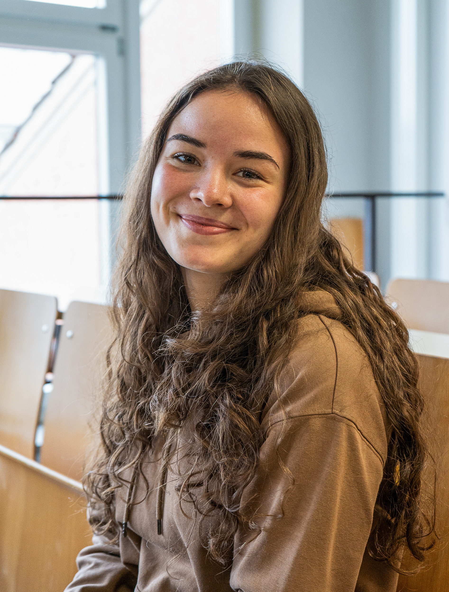 Studentin grinst in Kamera