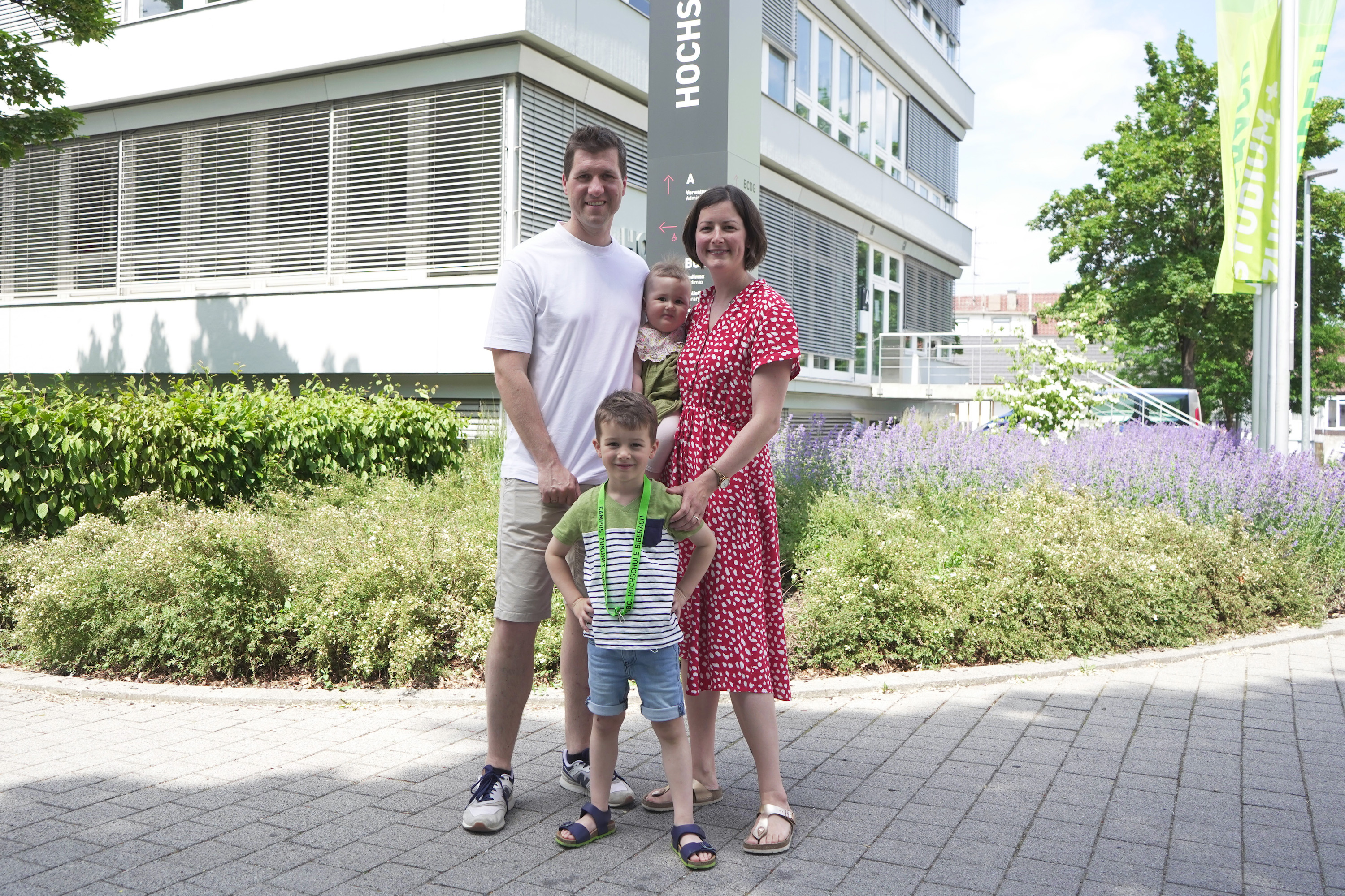 Mann, Frau und zwei Kinder vor Gebäude