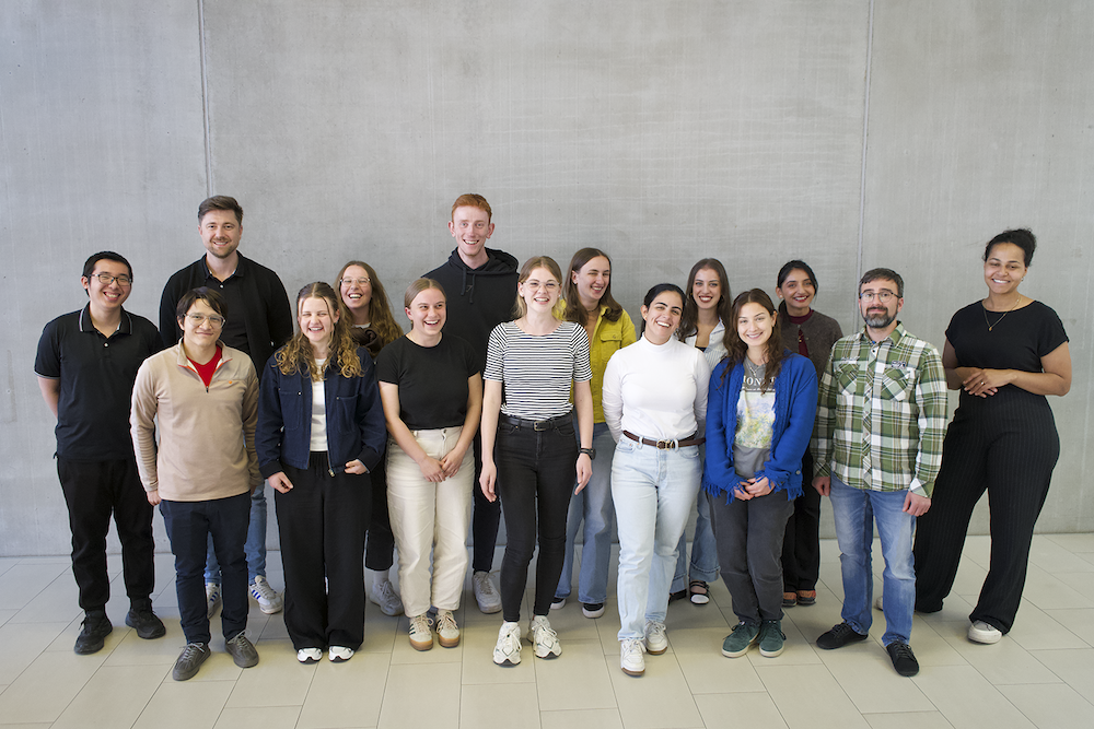 Gruppenfoto mit Studierenden vor einer Betonwand 