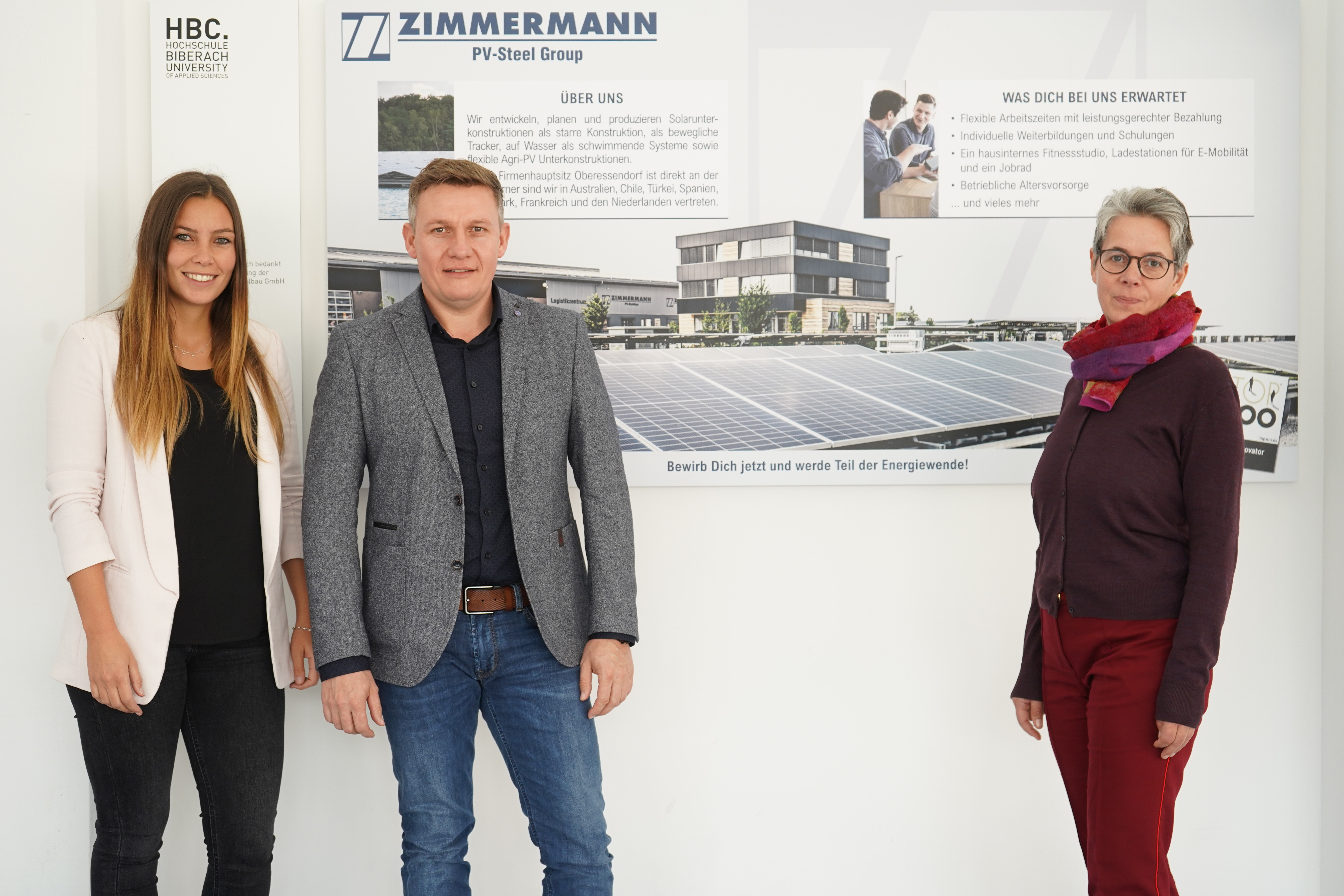 Drei Personen vor Logo PV Stahlbau