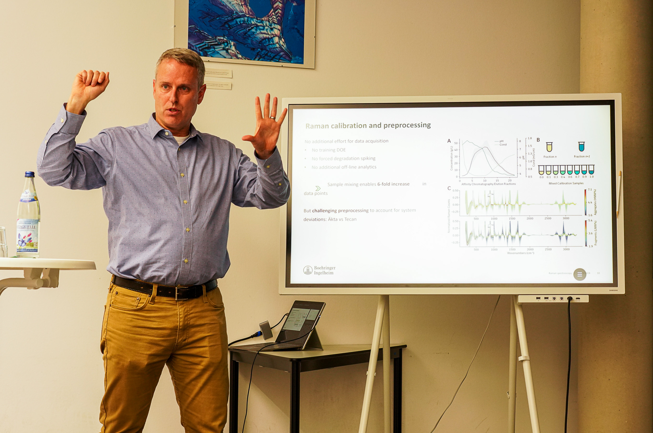 Mann steht vor einem Bildschirm und präsentiert