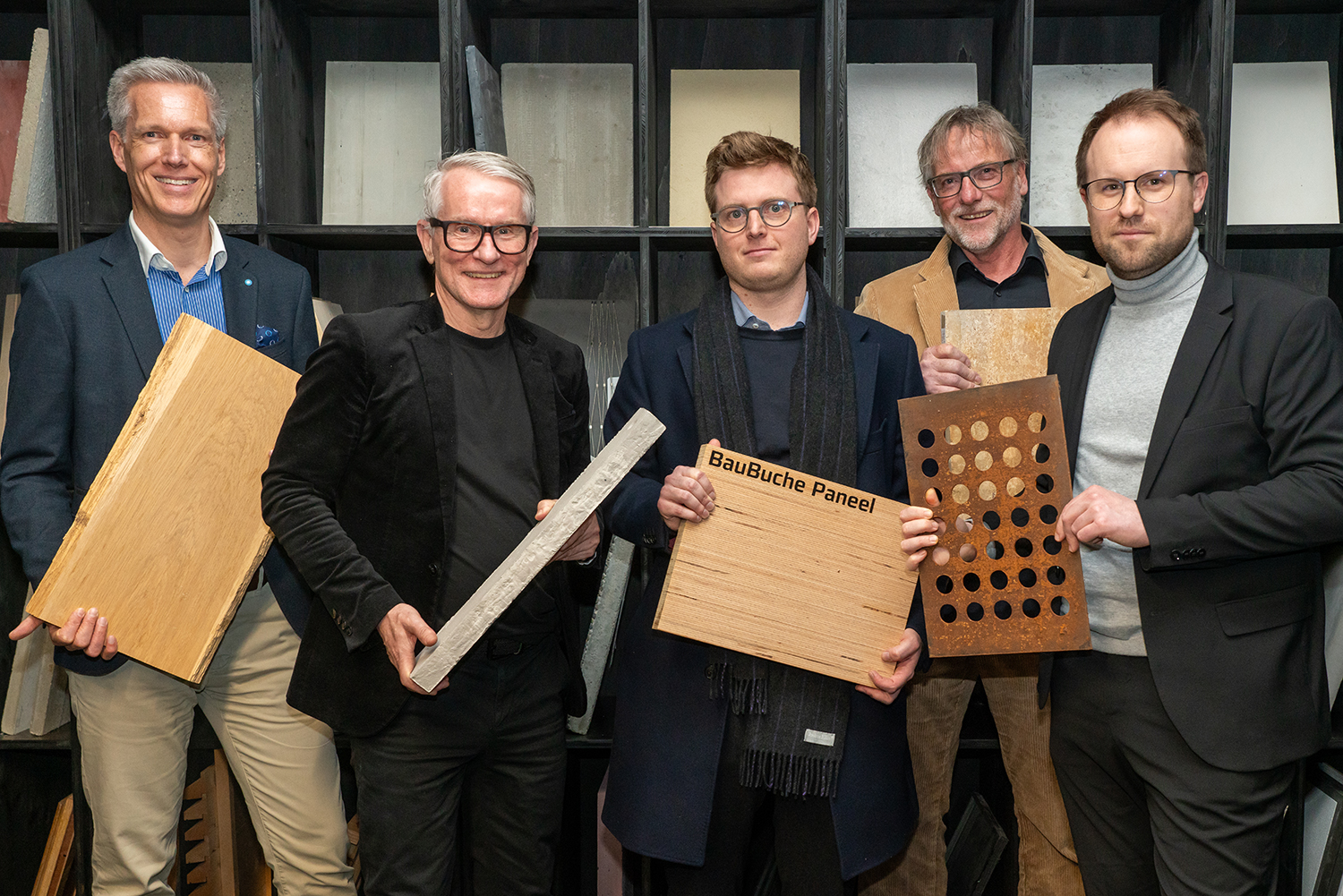 Fünf Männer stehend mit verschiedenen Materialien in der Hand