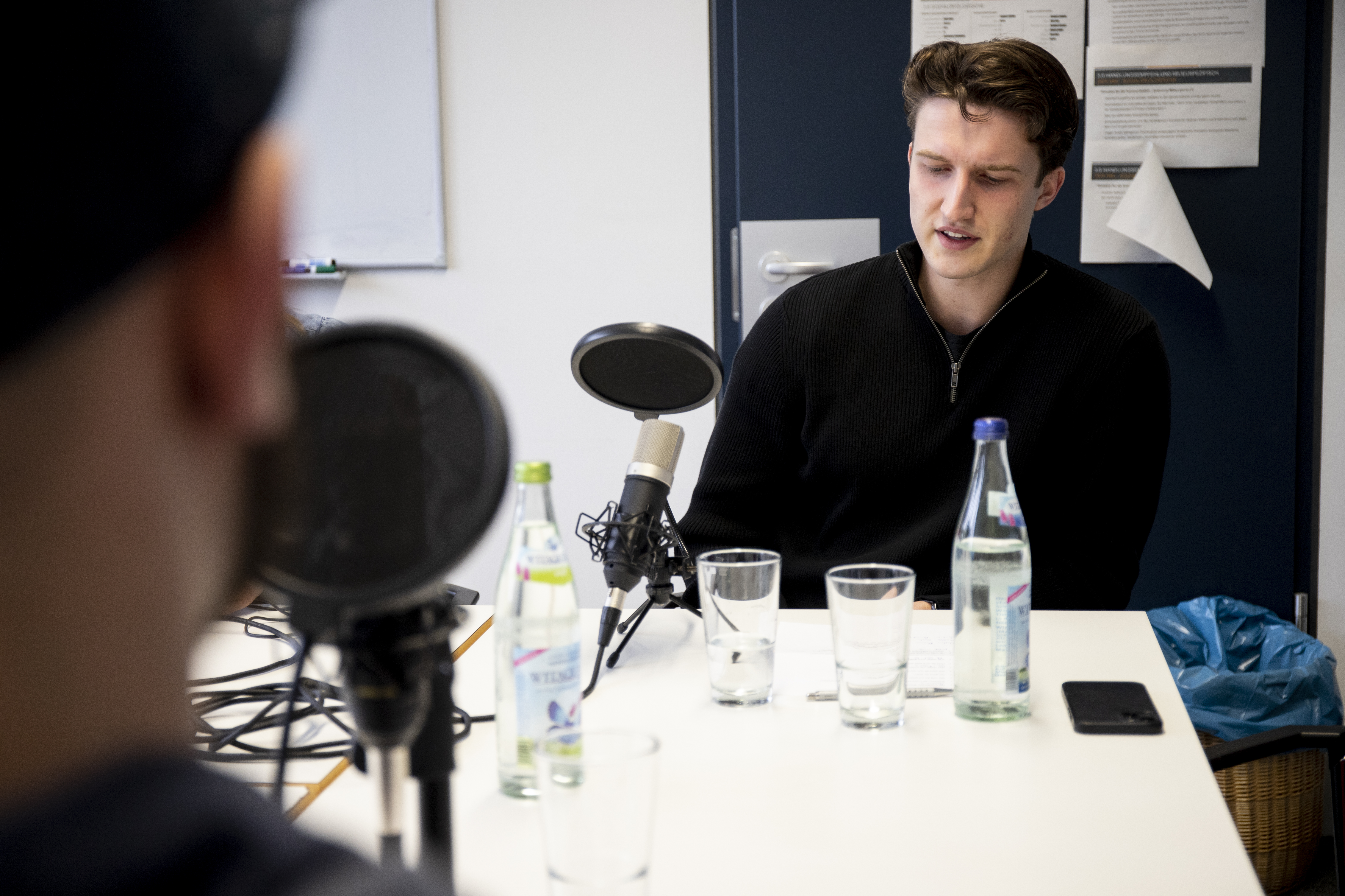 Mann bei Podcastaufnahme