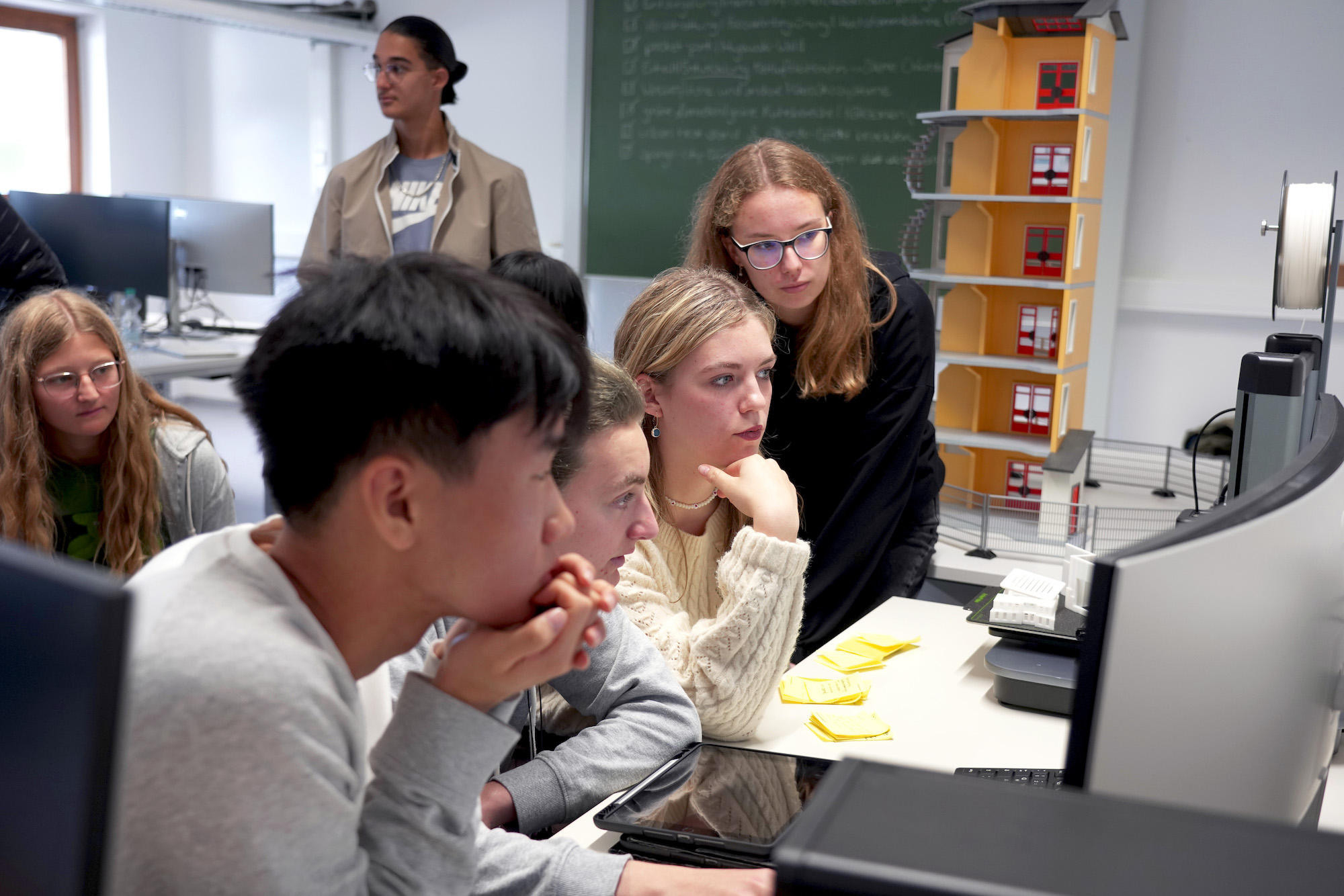 Schüler*innen vor einem PC