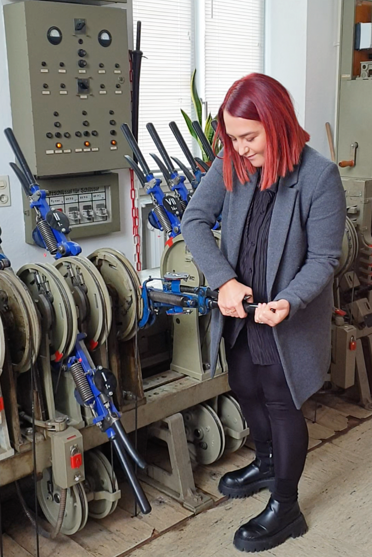 Studentin bei Betätigung eines Hebels (Zug)