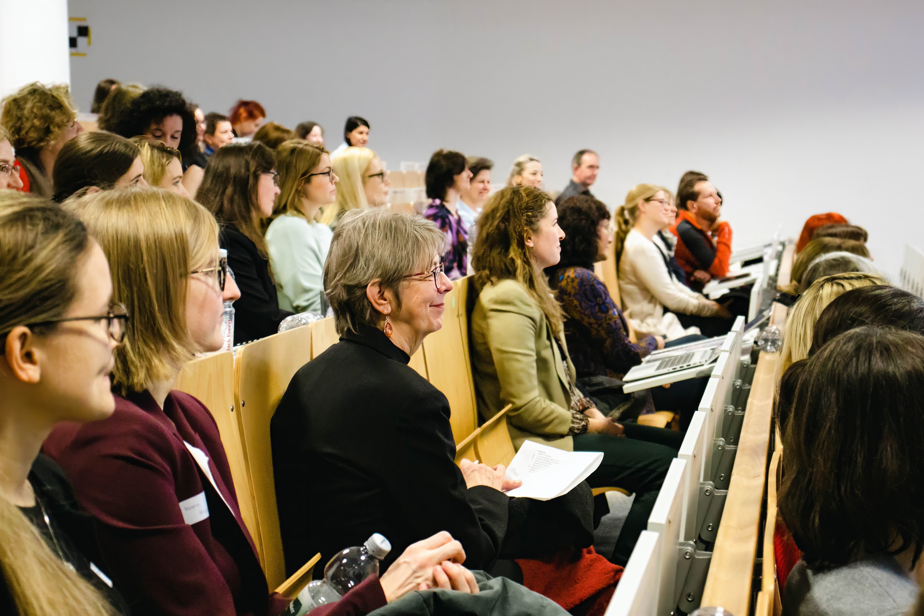 Frauen sitzen auf Stühlen in Hörsaal