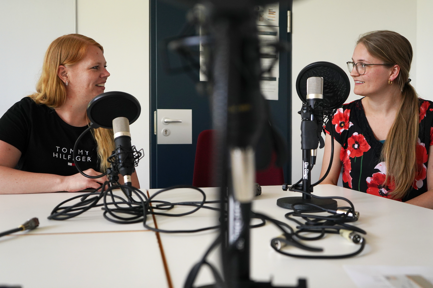 Zei Frauen sitzen am Mikrofon bei Podcastaufnahme
