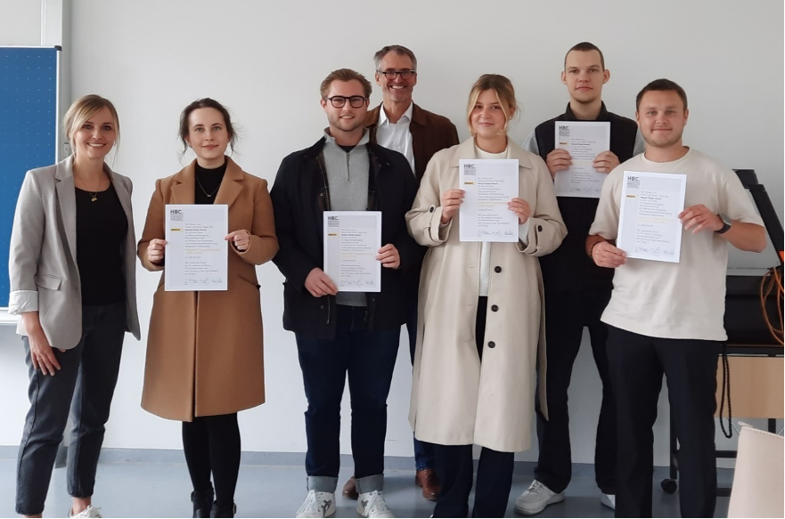 7 Personen mit Urkunden in der Hand