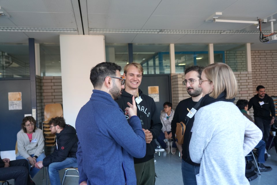 Vier Personen stehen in einem Kreis und unterhalten sich