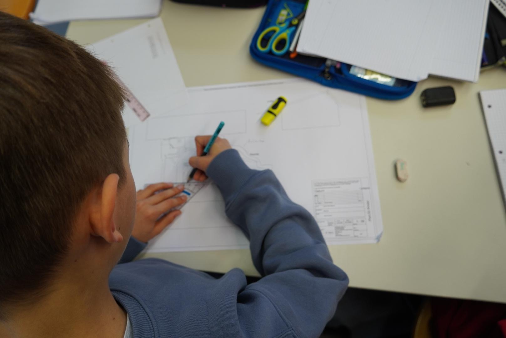 Kind zeichnet einen Plan