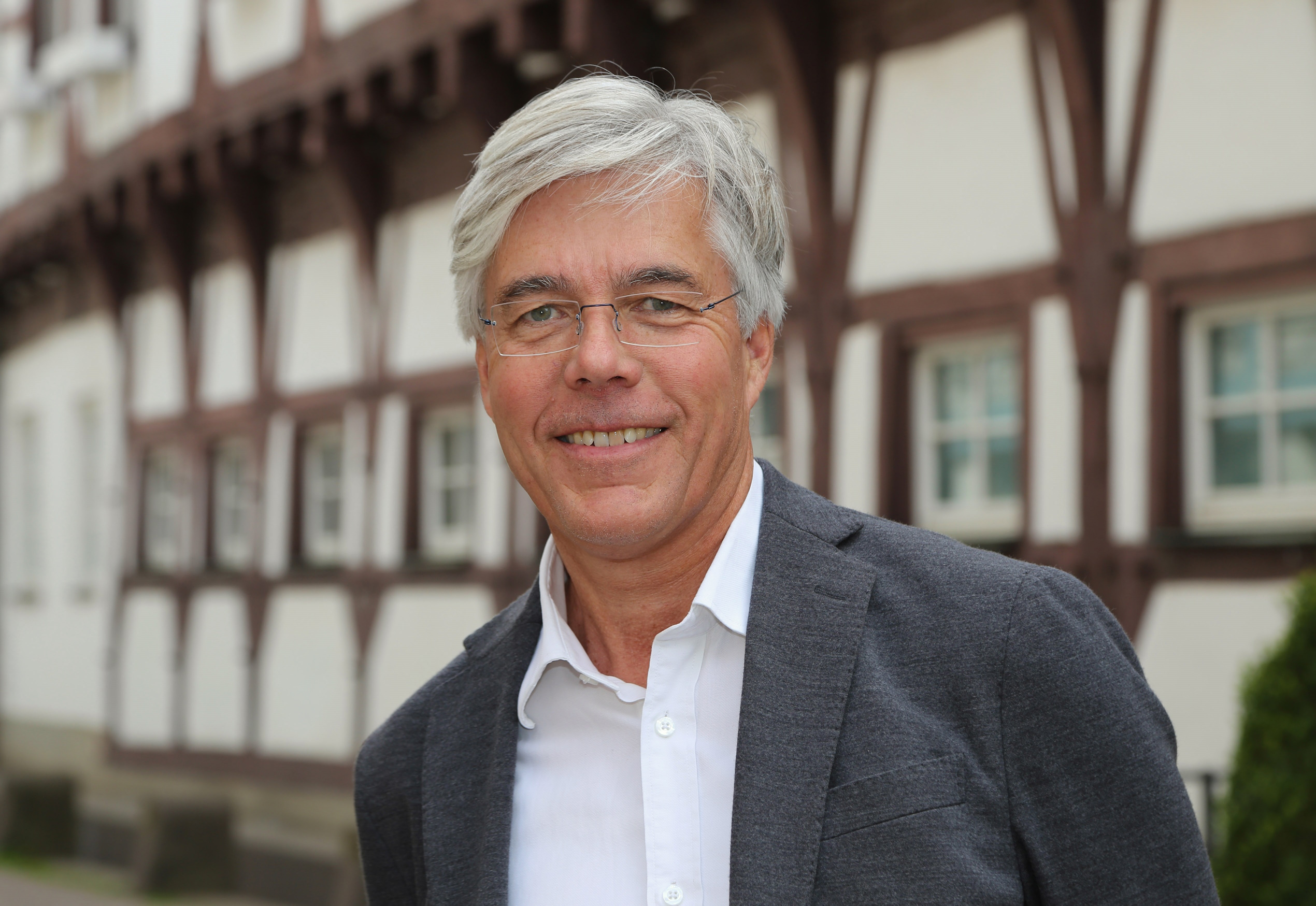 Mann im Porträt mittleren Alters vor historischem Gebäude