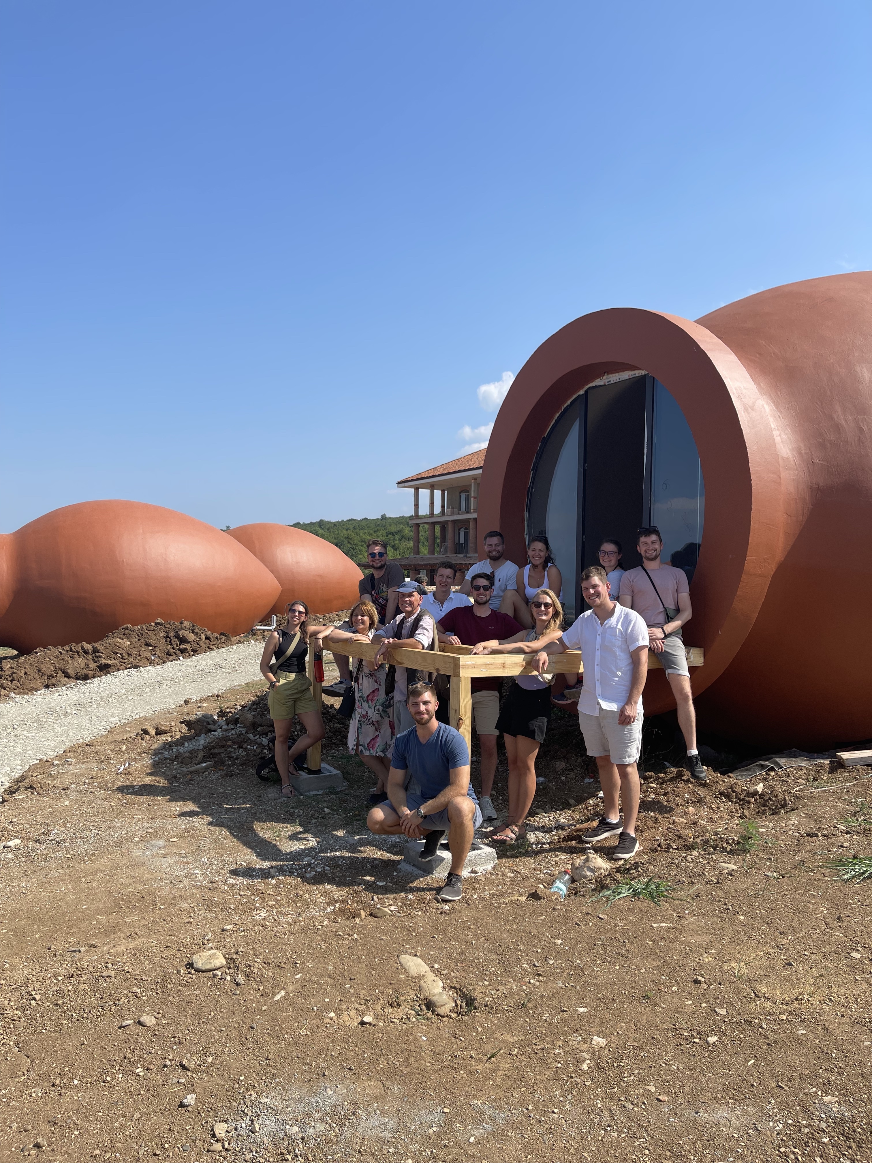 Gruppenbild vor roten Fässern aus Beton