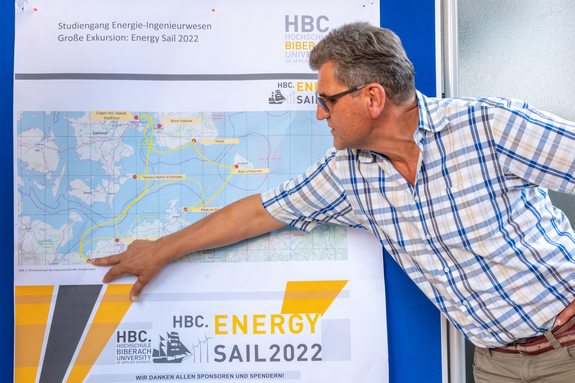 Mann zeigt Segelroute auf einer Karte