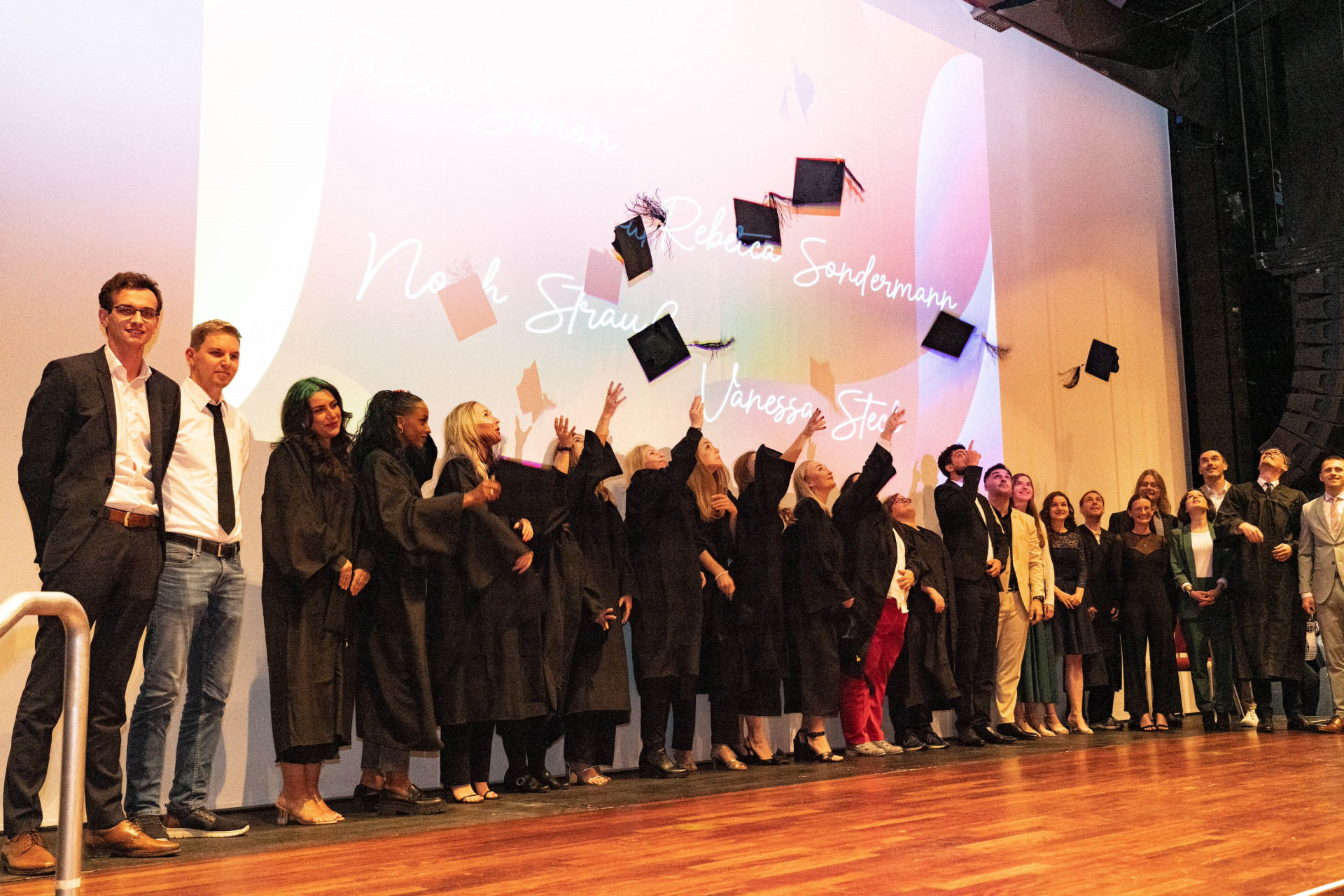 Studierende werfen Absolventenhüte in die Luft