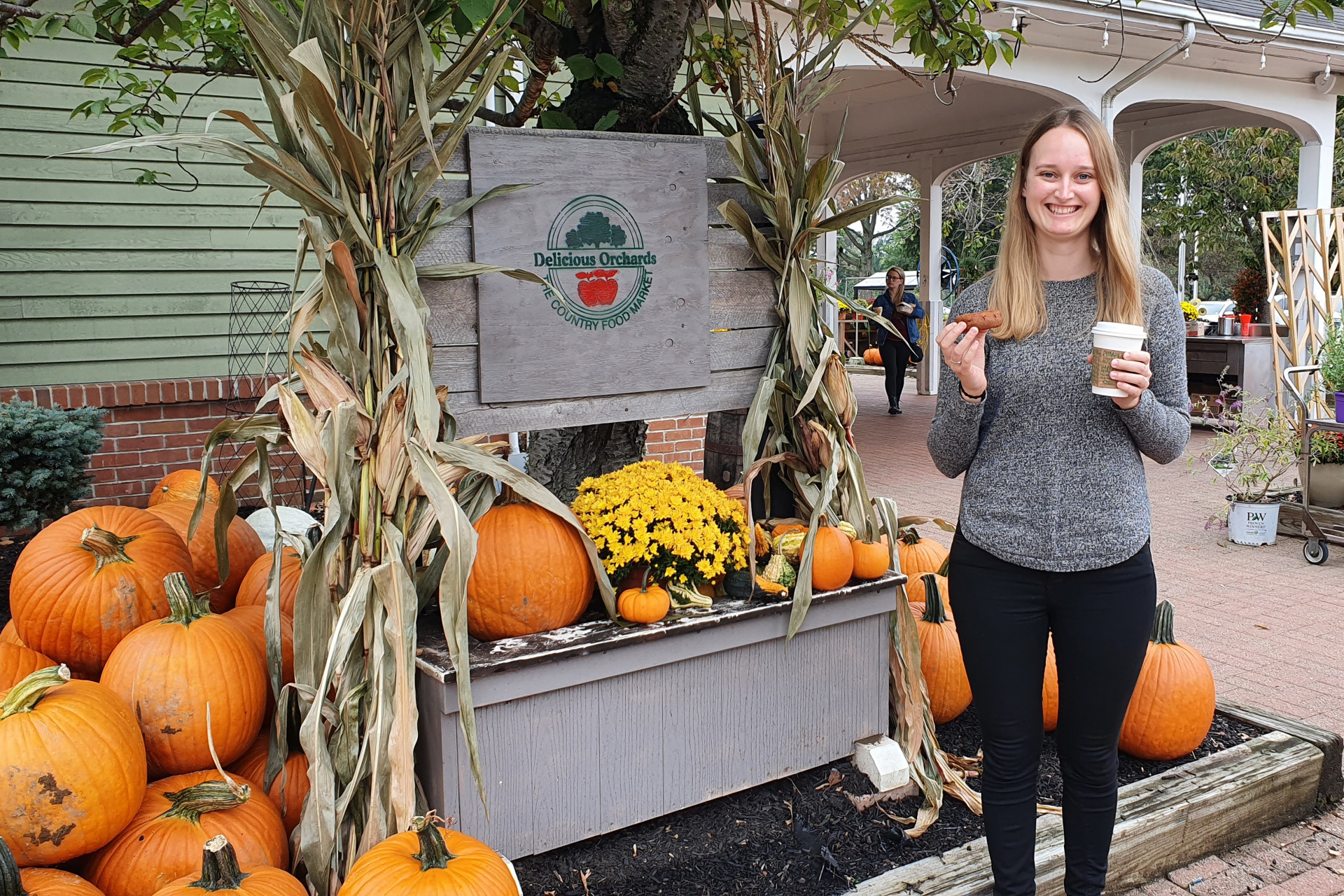 Junge Frau vor einem Kürbisstand in Amerika