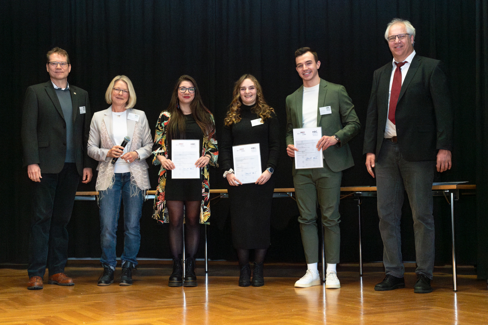 Personen mit Urkunden auf der Bühne