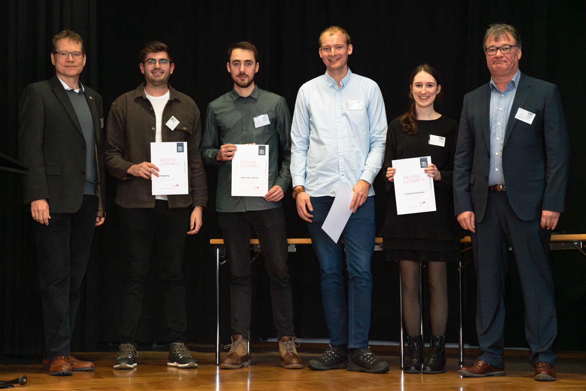 Personen mit Urkunden auf der Bühne