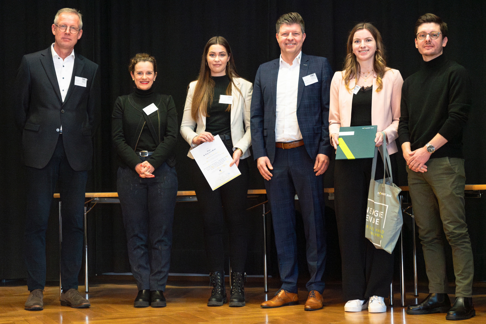 Personen mit Urkunden auf der Bühne