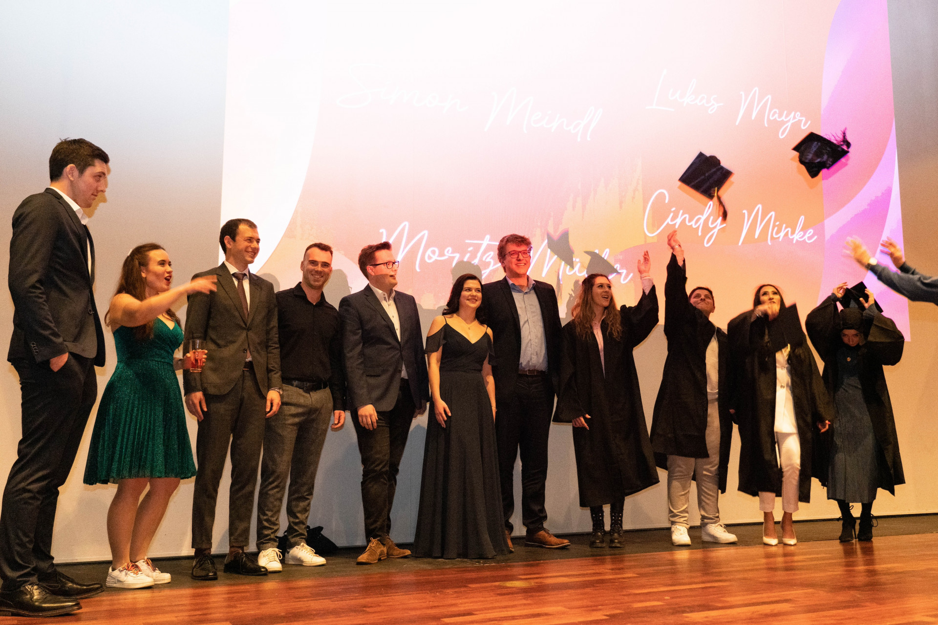 Studierende werfen Absolventenhüte in die Luft