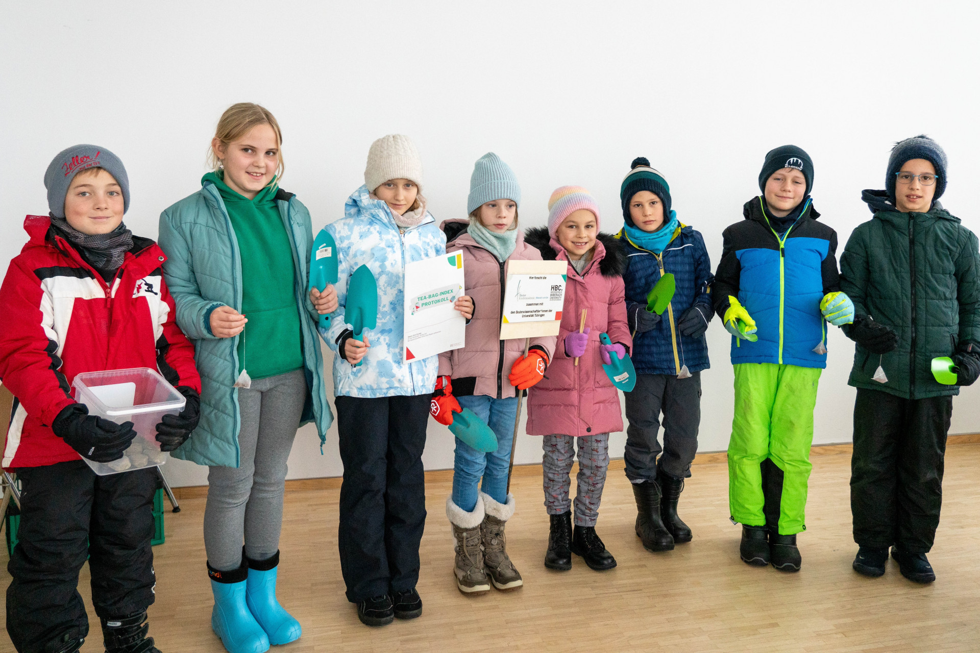 vier Jungen und vier Mädchen haben sich für Gruppenbild positioniert