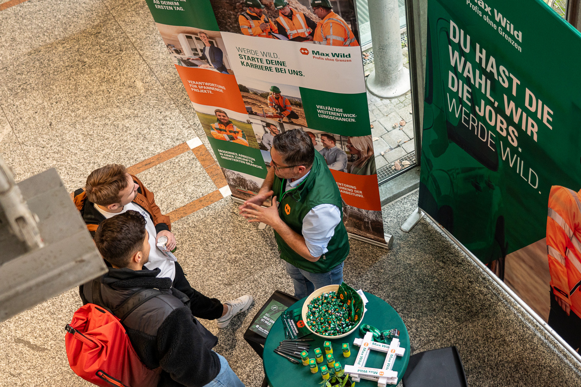 Personen stehen an einem Messestand