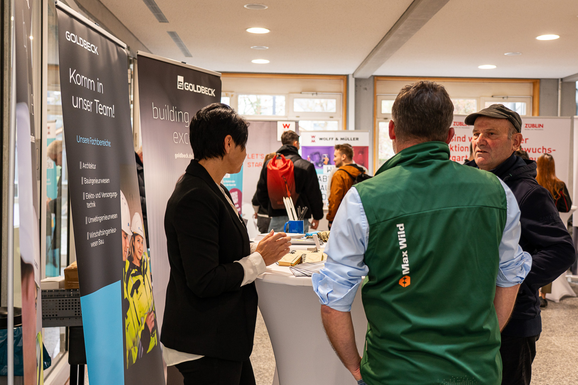 Personen stehen an einem Messestand
