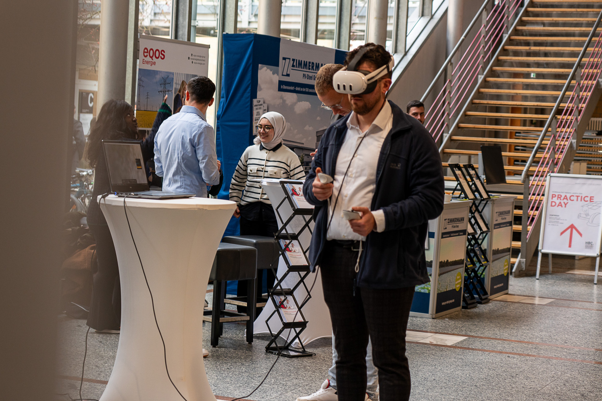 Mann steht mit VR-Brille an Messestand