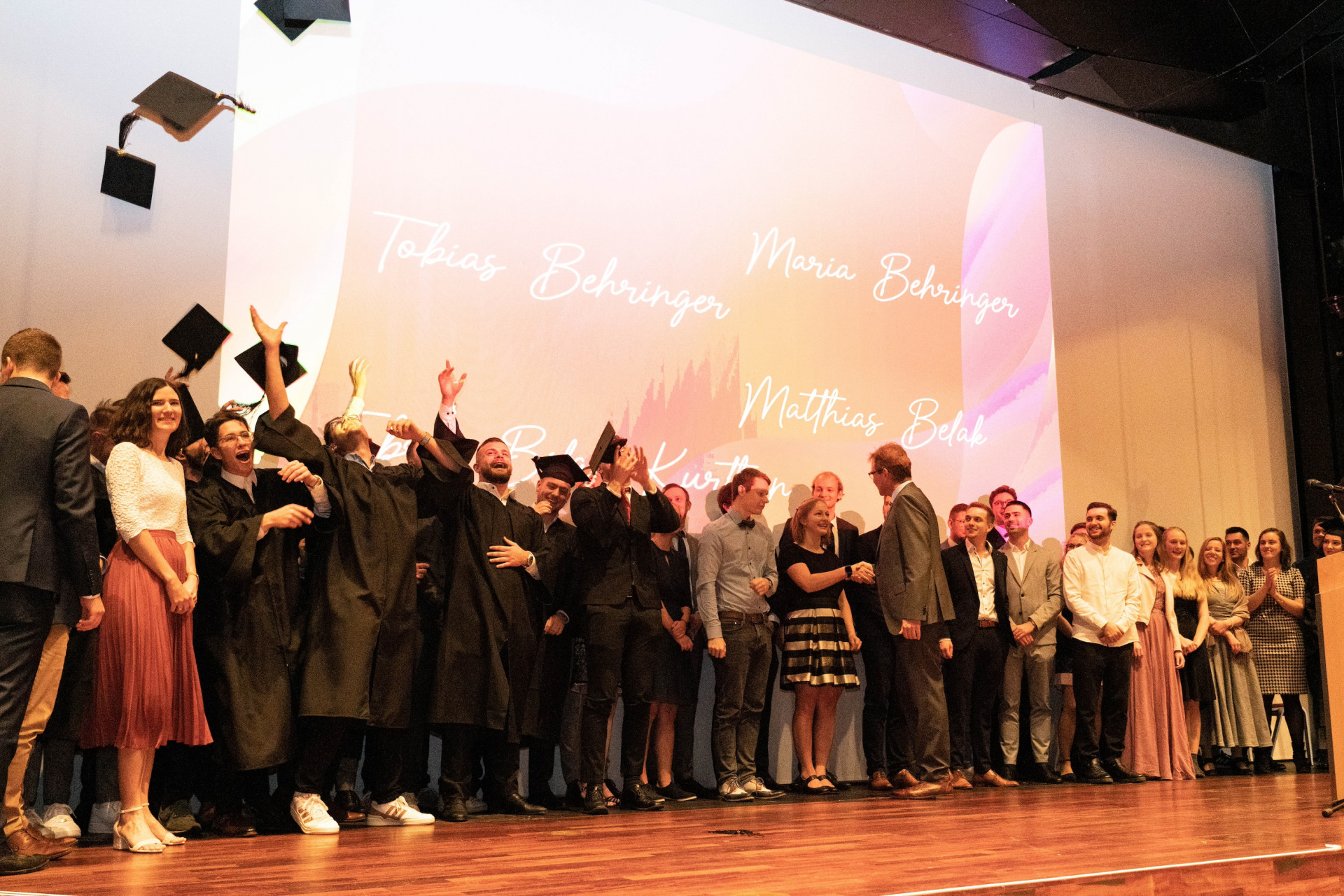 Studierende werfen Absolventenhüte in die Luft