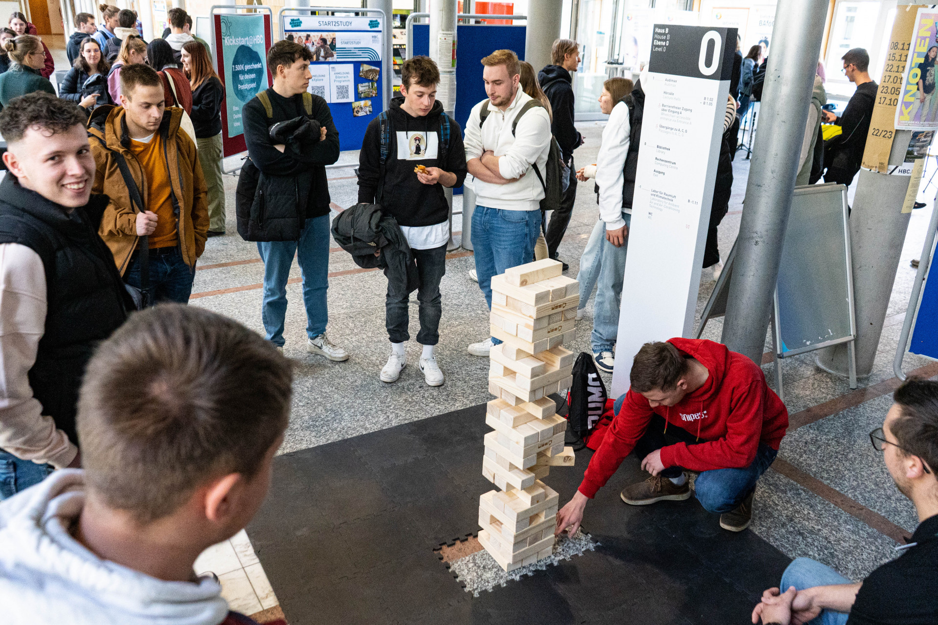 Studierende beim Spielen mit riesen Jenga-Turm