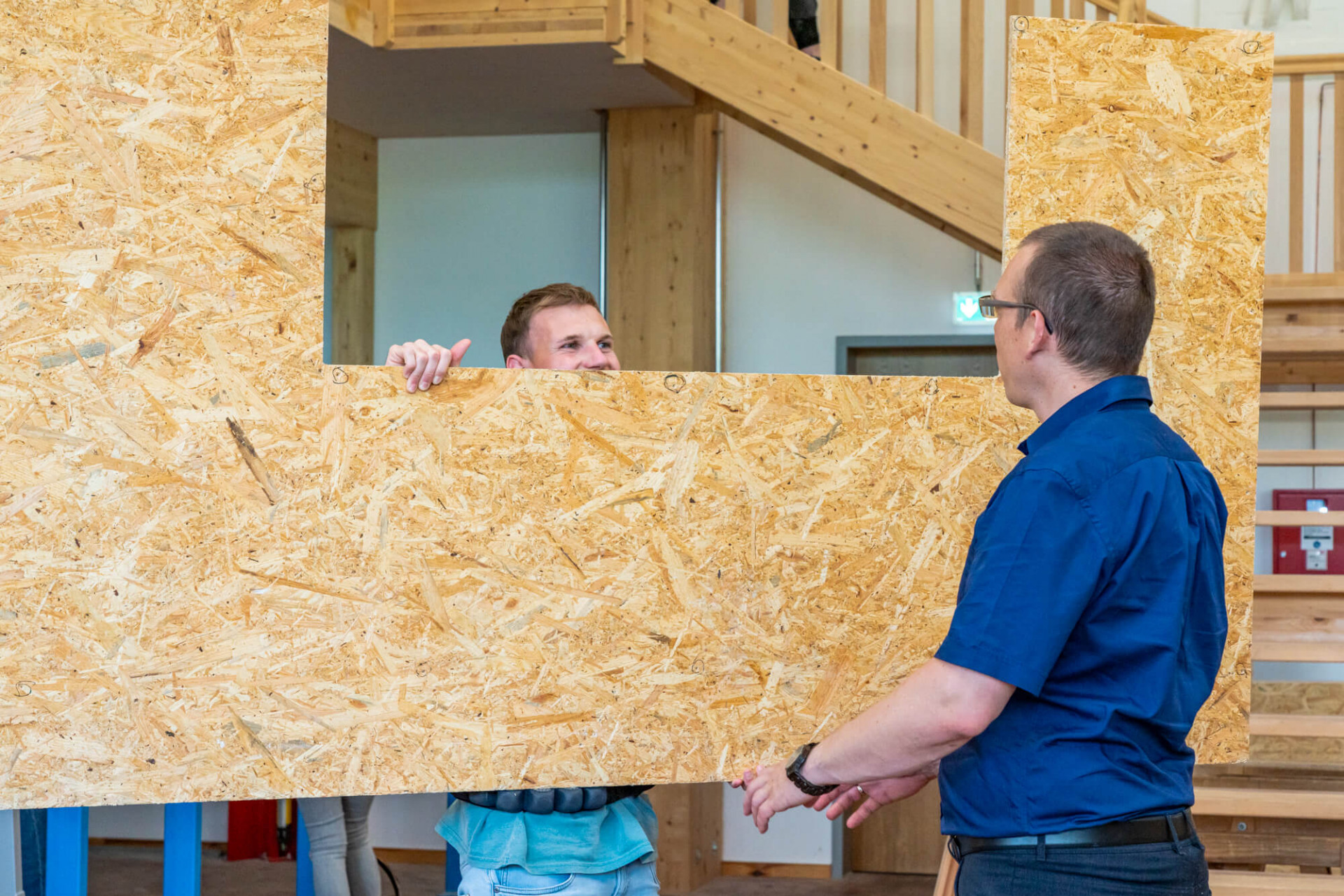 Mit Hilfe eines Exoskeletts wird eine große Holzplatte getragen