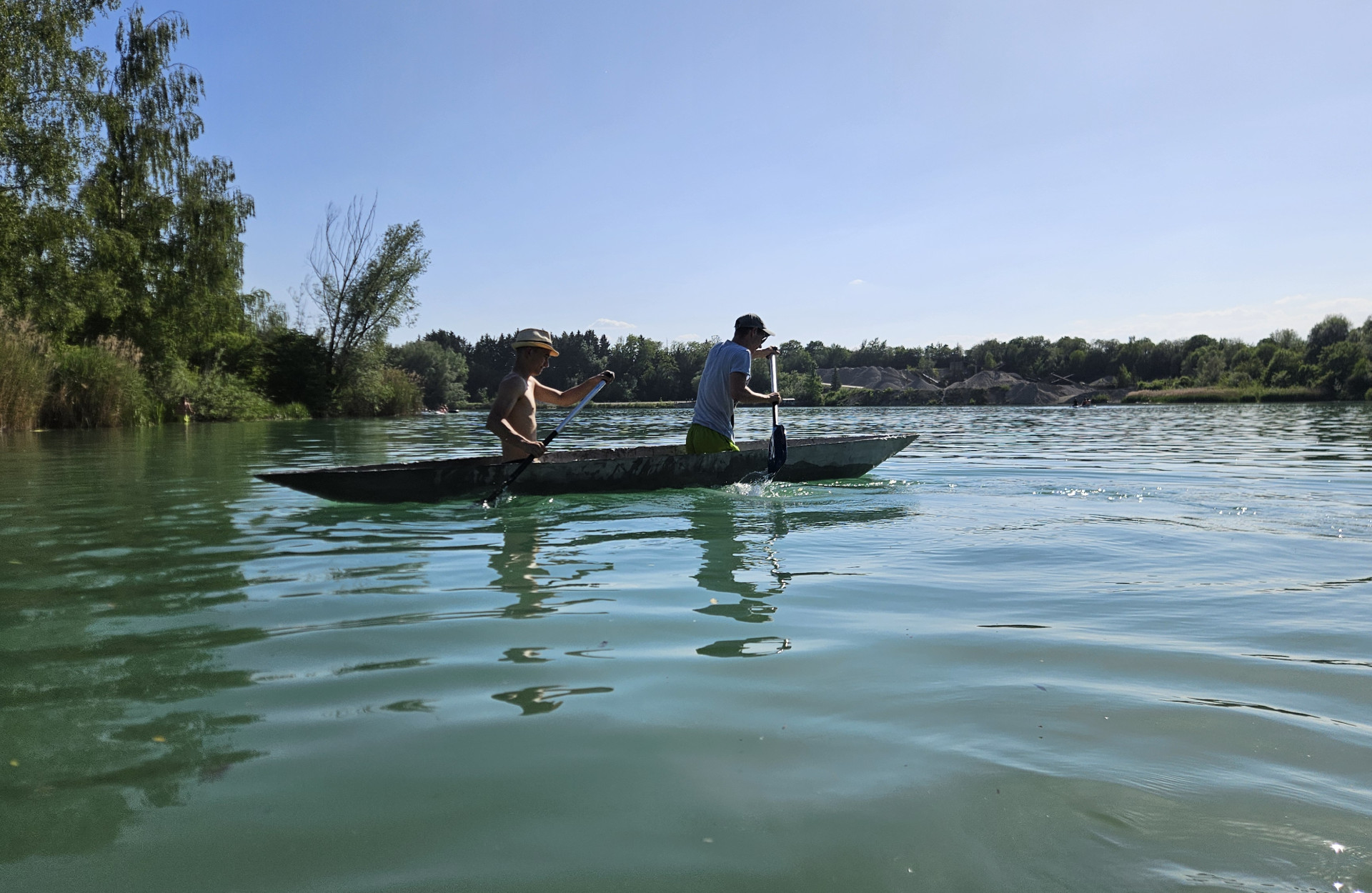 Zwei Männer in einem Betonkanu auf dem See