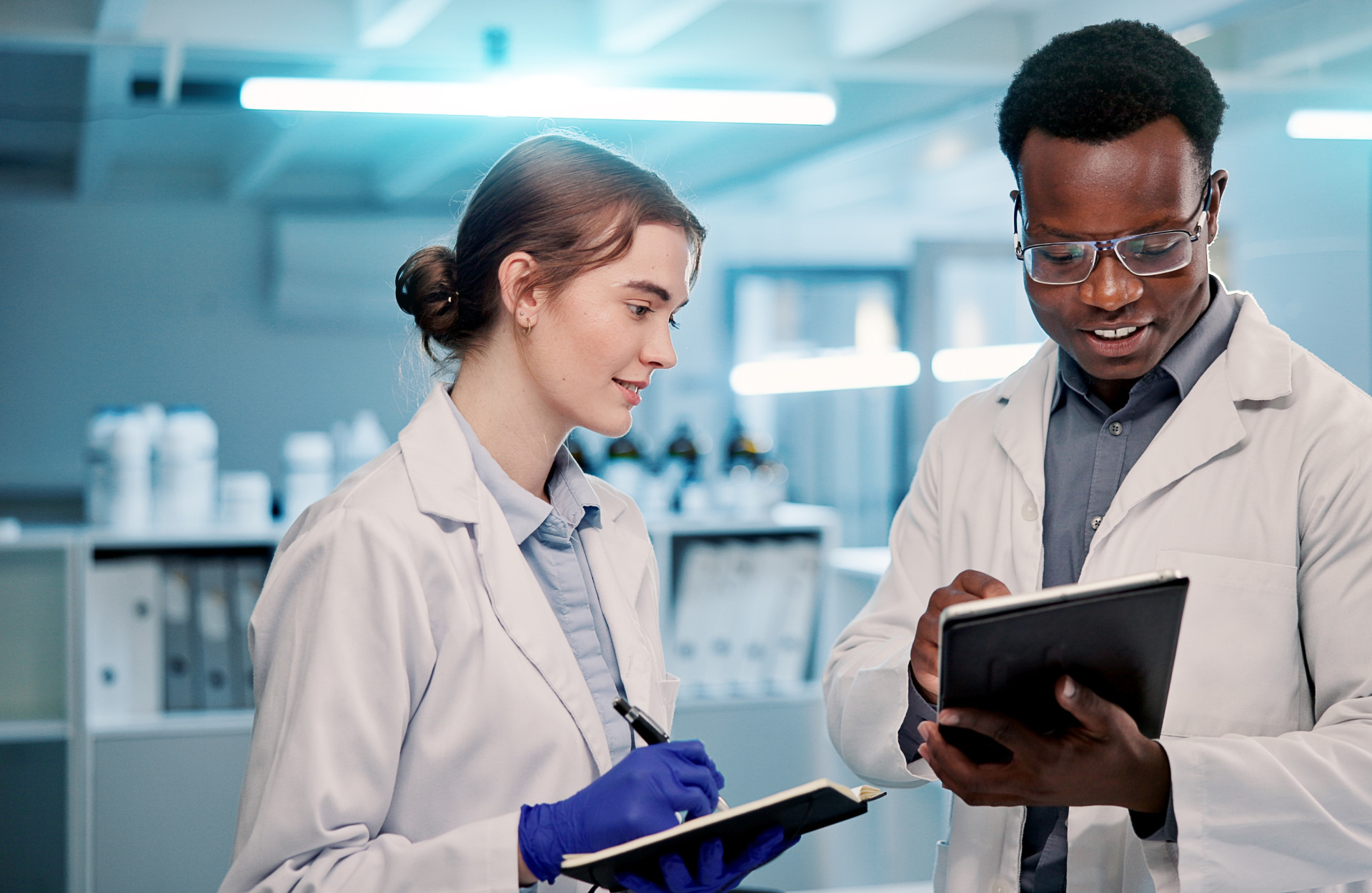 Ein Mann und eine Frau stehen im Labor mit Tablets in der Hand