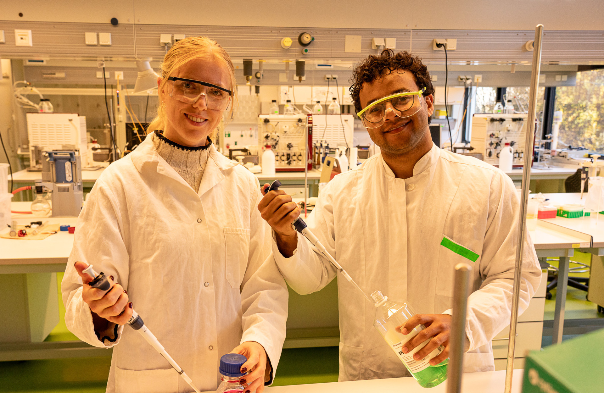 Eine junge Frau und ein junger Mann stehen im Labor und arbeiten