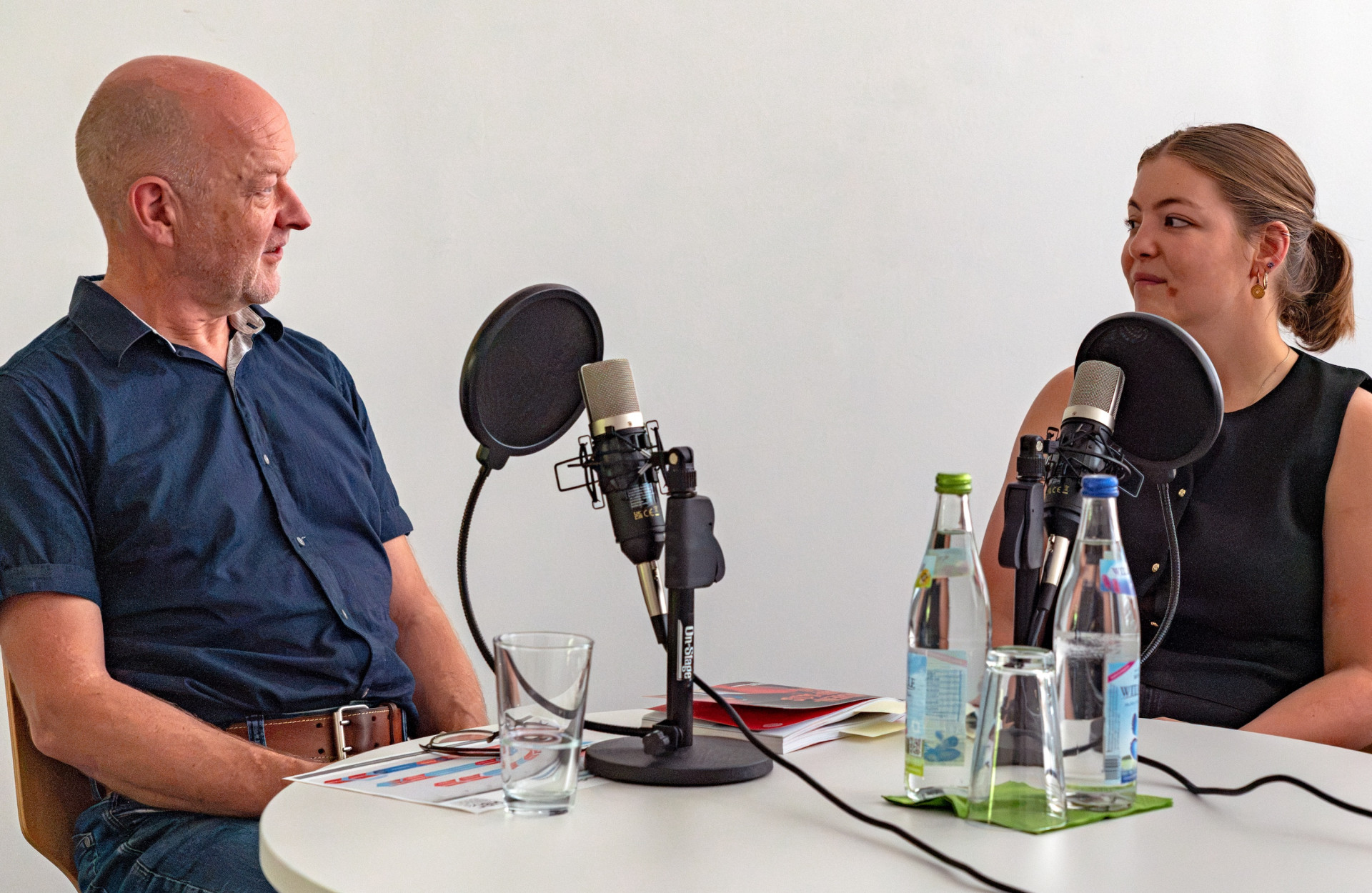 Zwei Personen sitzen bei einer Podcastaufnahme