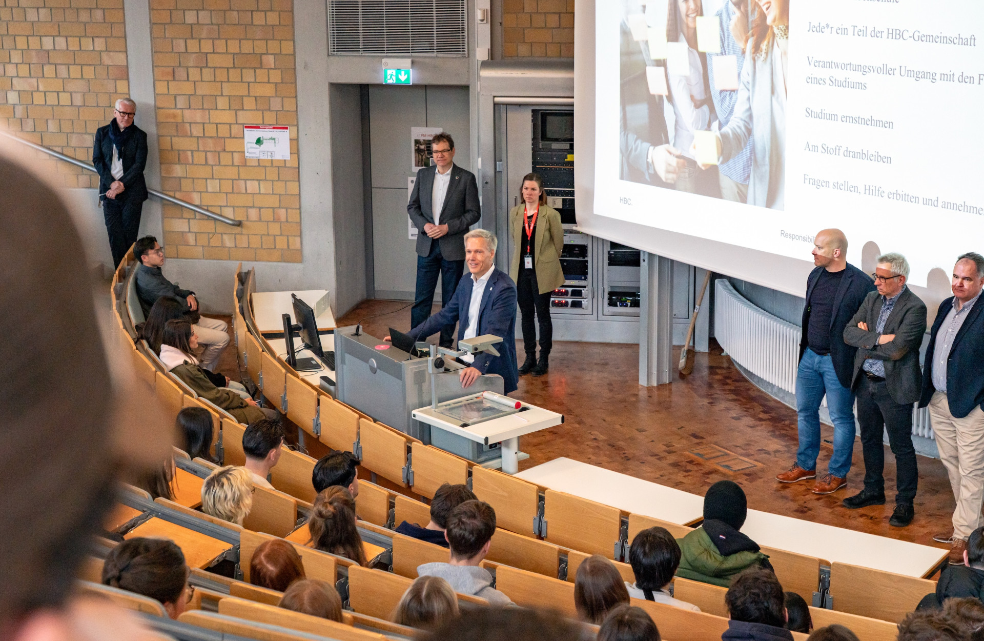 Prof. Bahr steht im Hörsaal und begrüßt Studierende