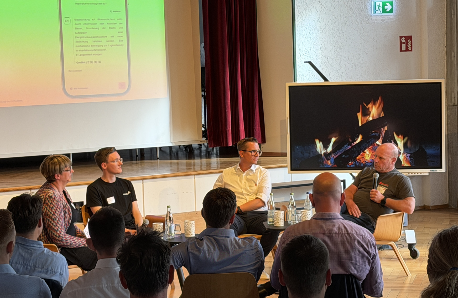 Personen sitzen bei einer Podiumsdiskussion vor Publikum
