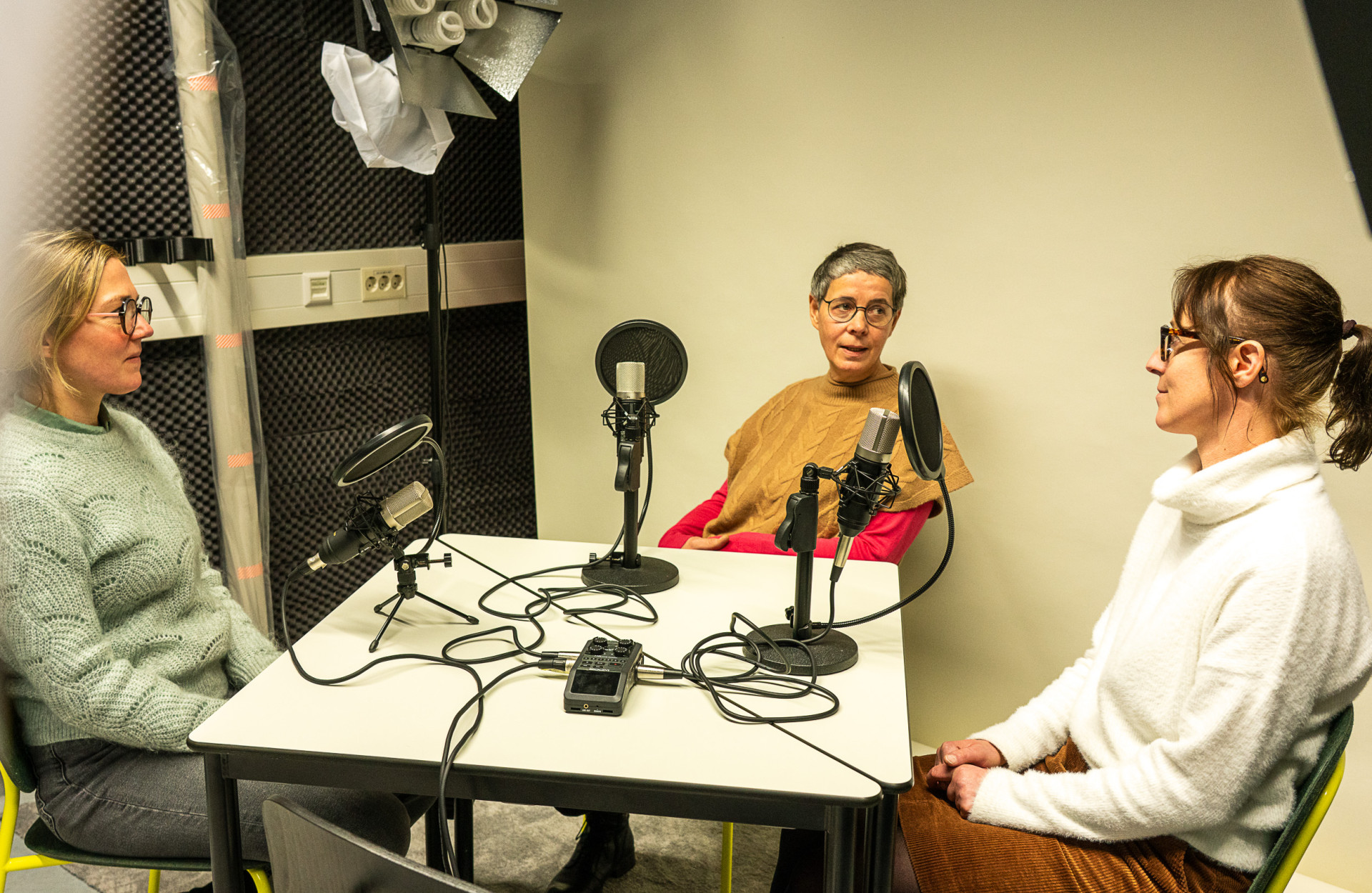 Drei Frauen sitzen bei einem Podcast am Tisch 