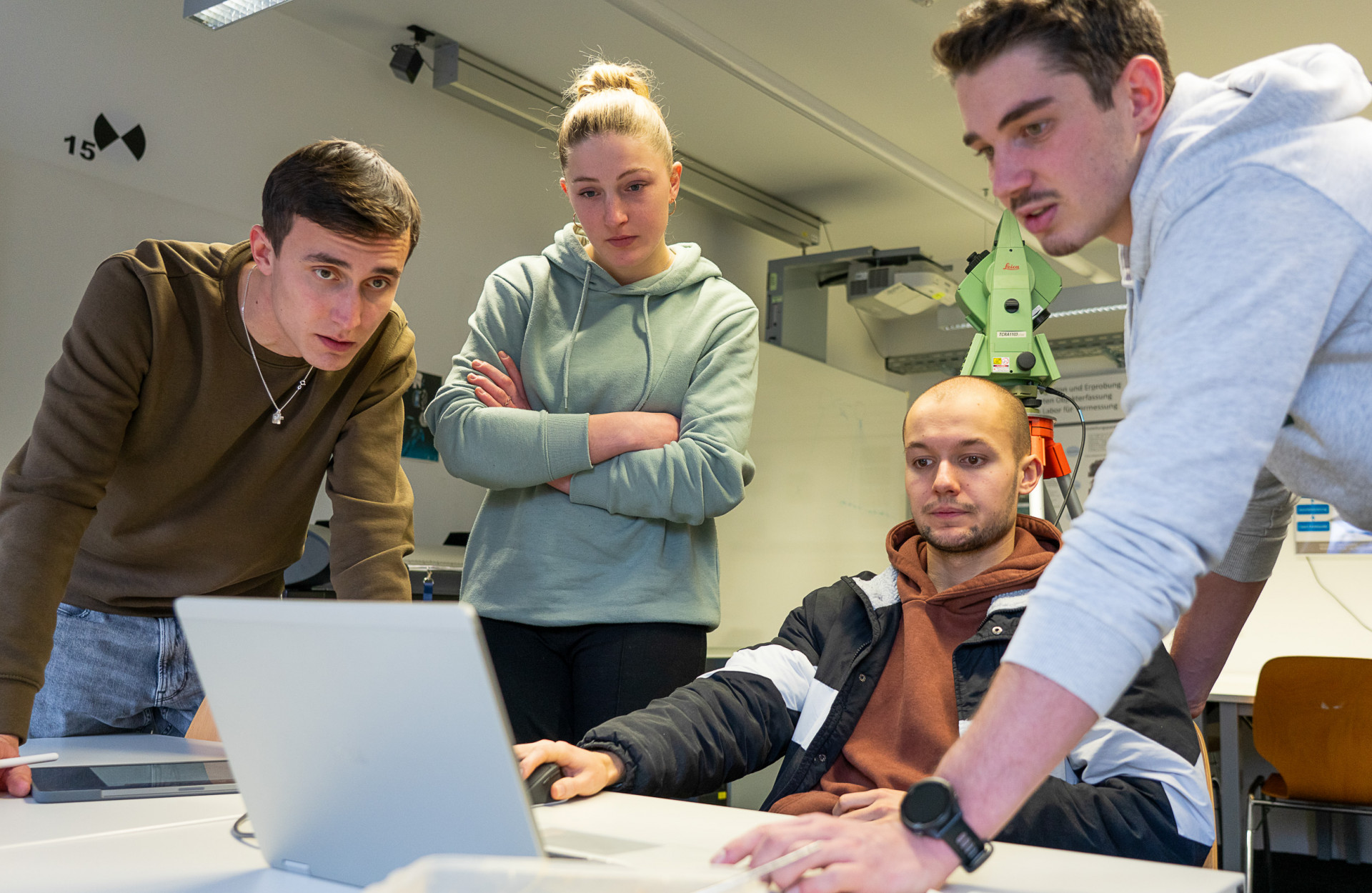 Vier Studierende arbeiten an einem Laptop