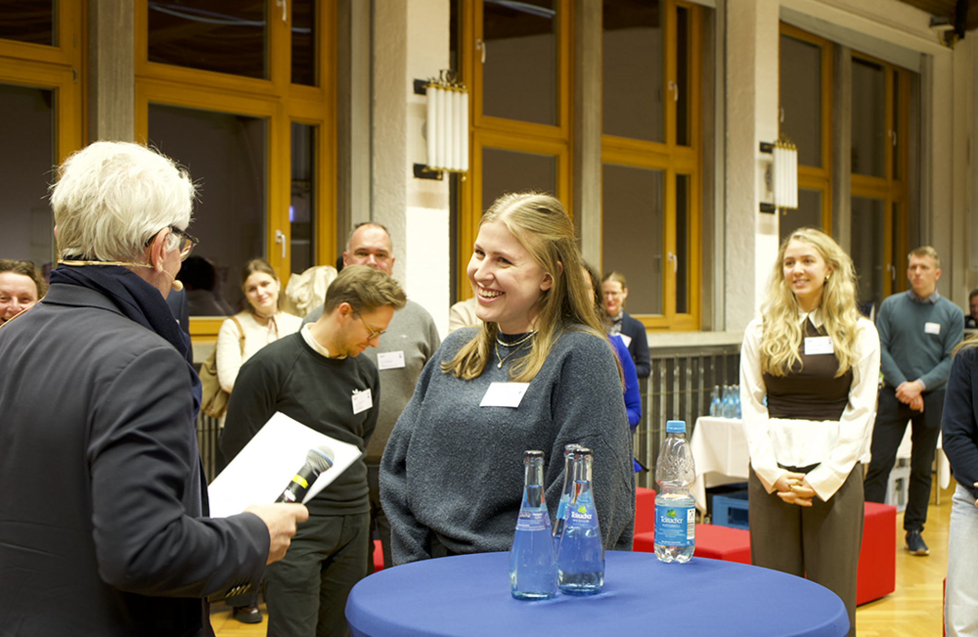 Mann übergibt Urkunde an Studentin